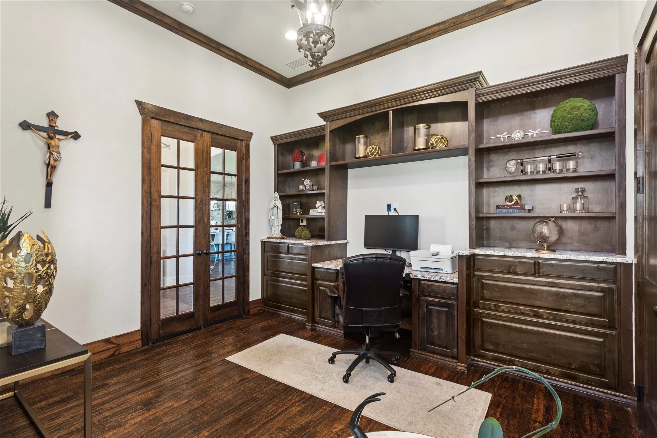 Wood-finish flooring, built-in cabinetry with shelving, French doors with glass panes, crown molding, and granite-look countertops
