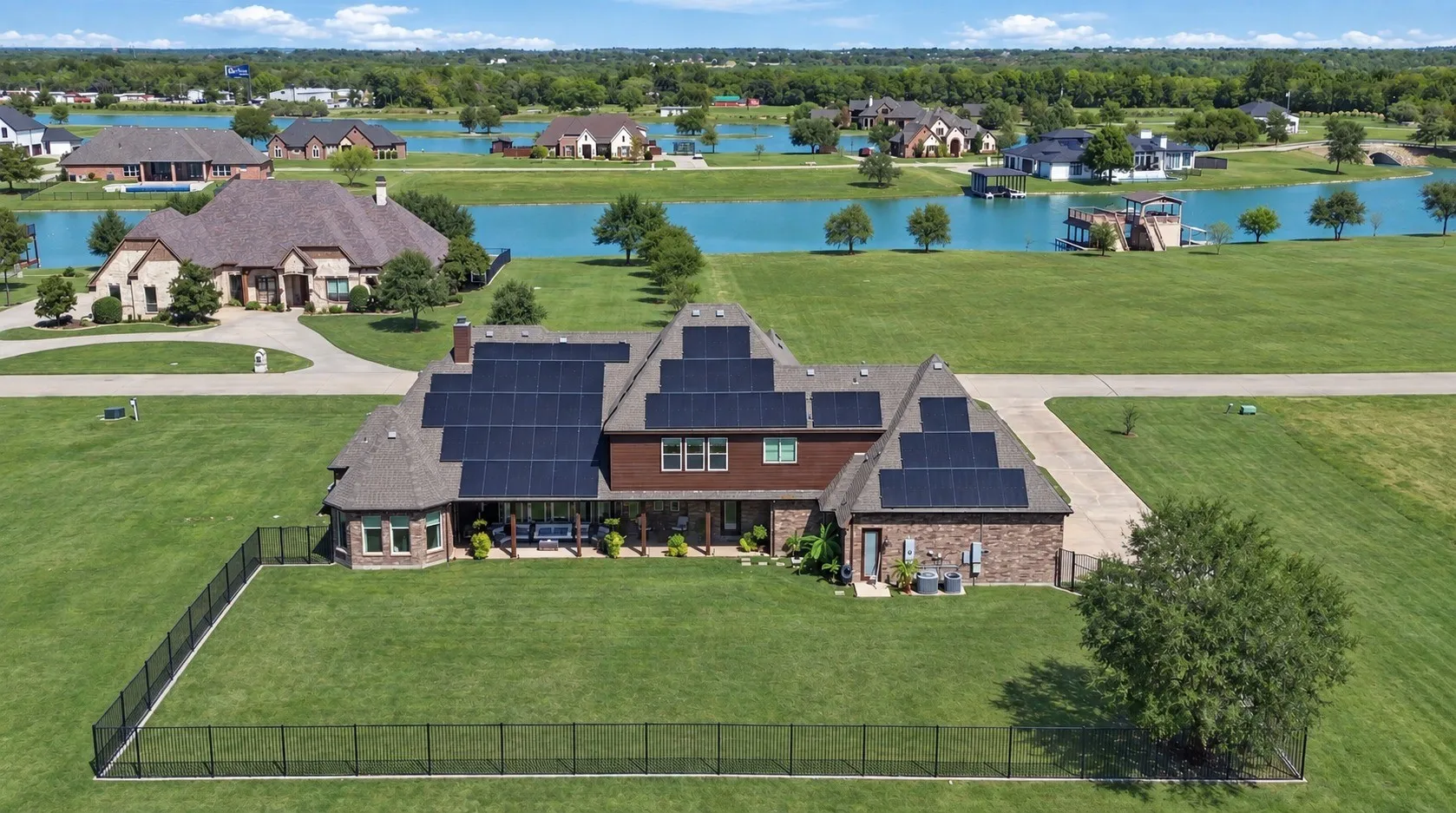 Brick exterior with multiple solar panel arrays, stone accents, and a covered back patio