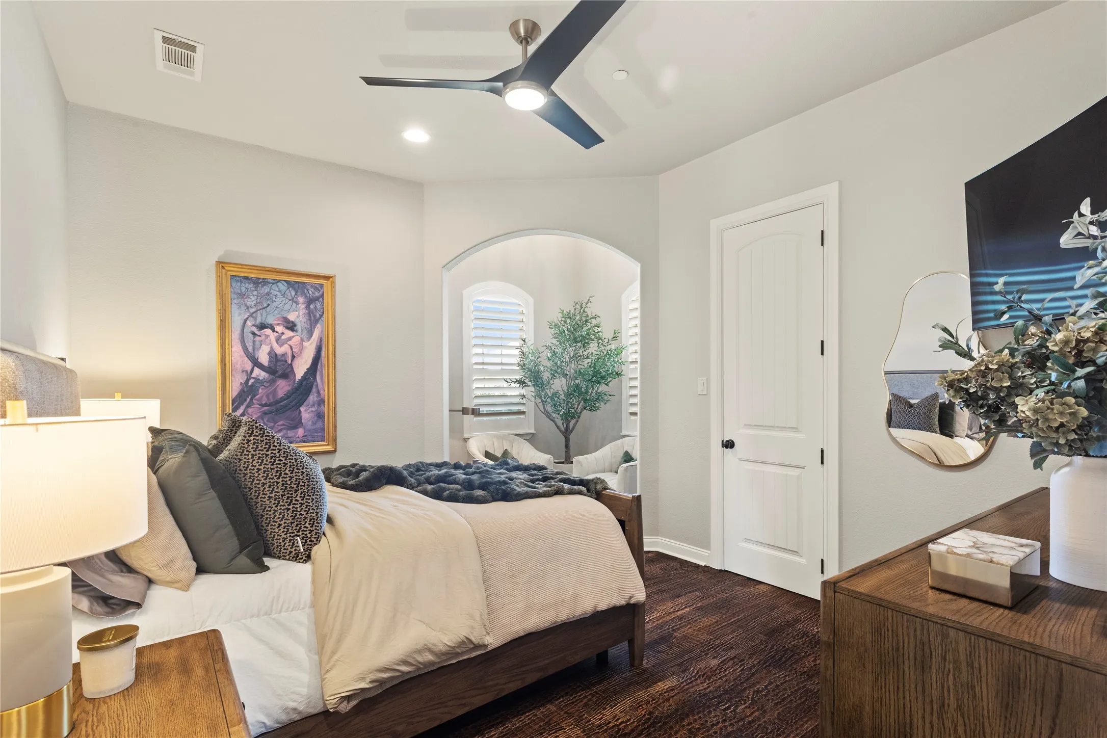 Recessed lighting, ceiling fan, arched doorway, wood-finish flooring, and a paneled interior door