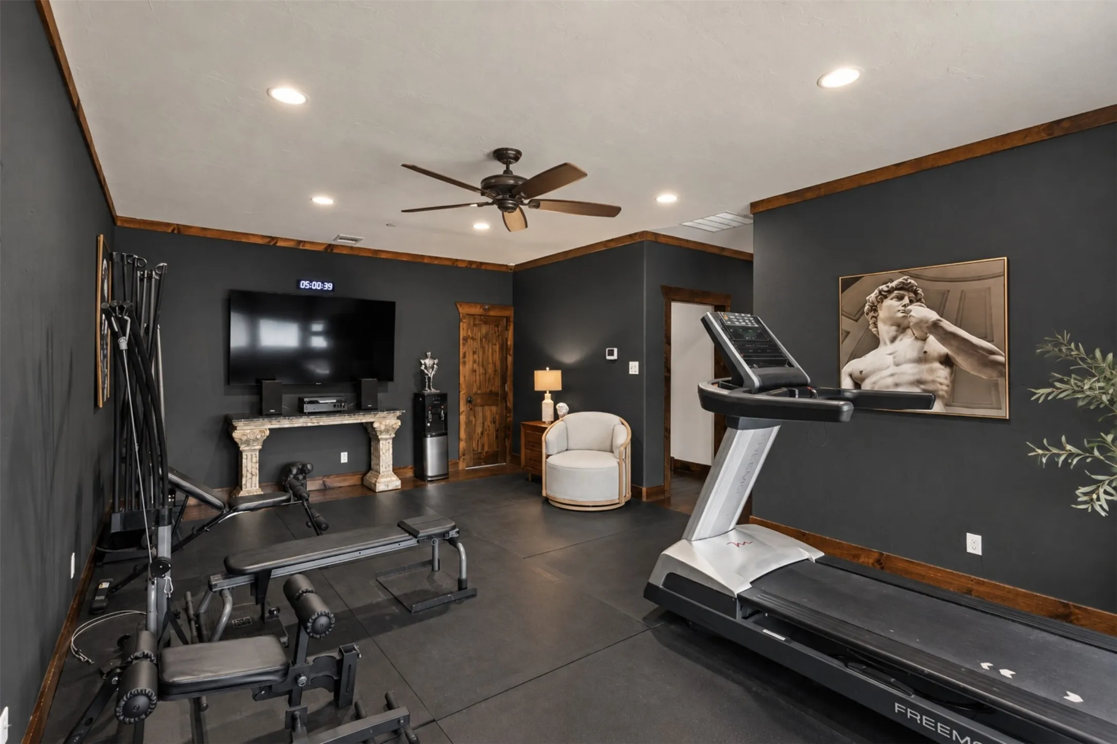 Recessed lighting, ceiling fan, dark-toned walls, and wood-trim accents