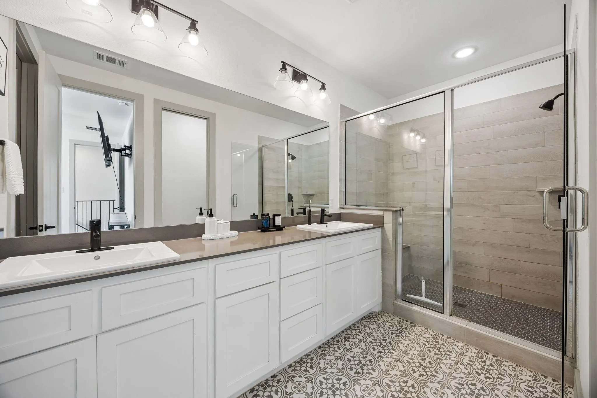 The primary bath features dual sinks and a  walk-in shower.