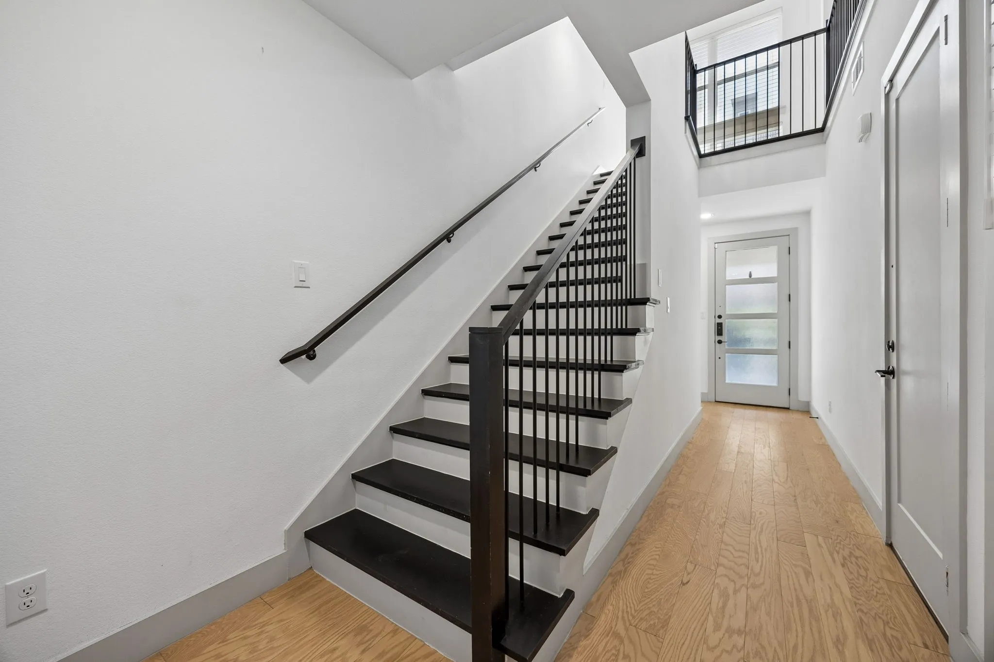 A staircase with wood treads leads up to the kitchen and living space.