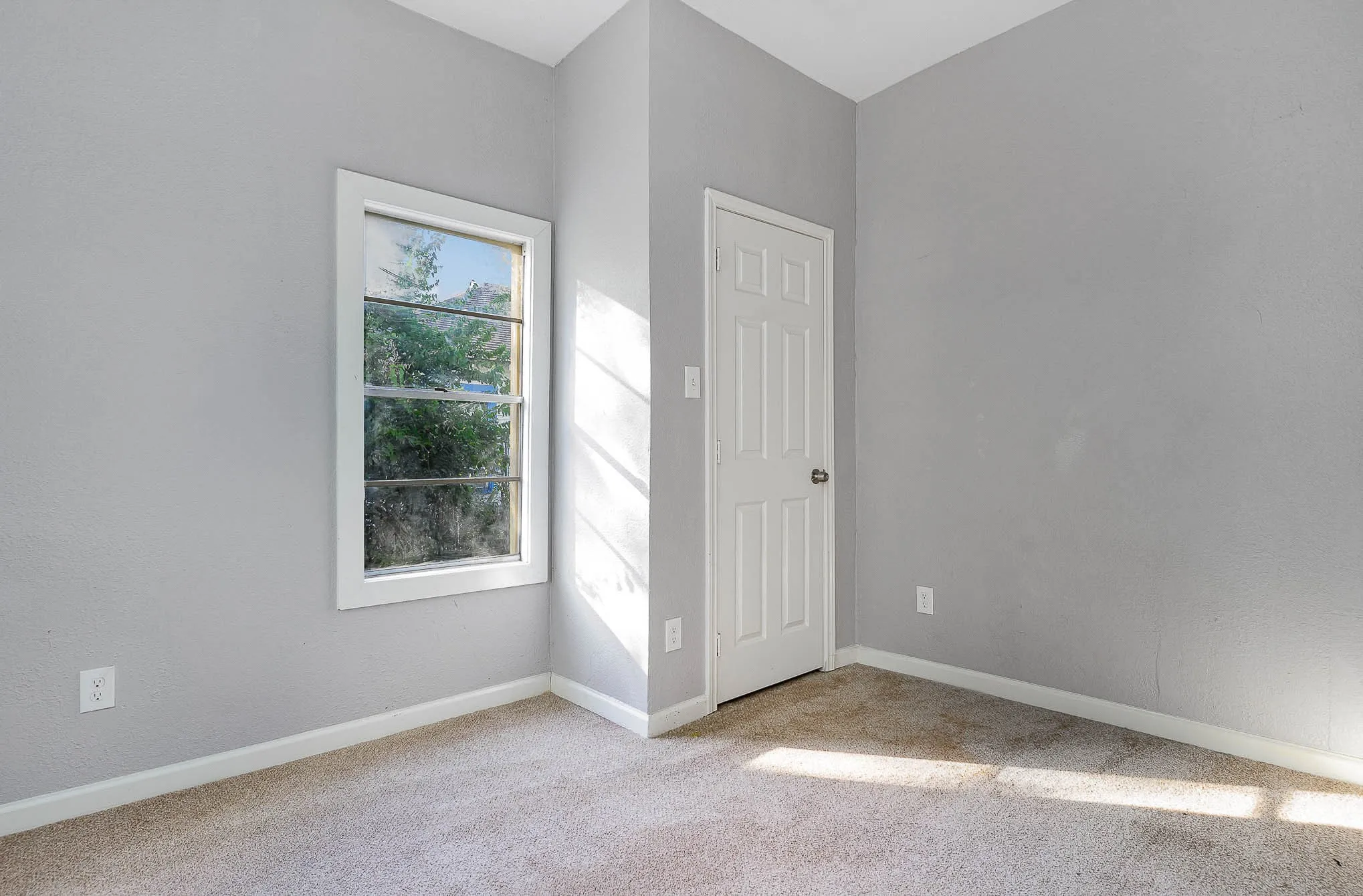 Empty room with carpet floors and baseboards
