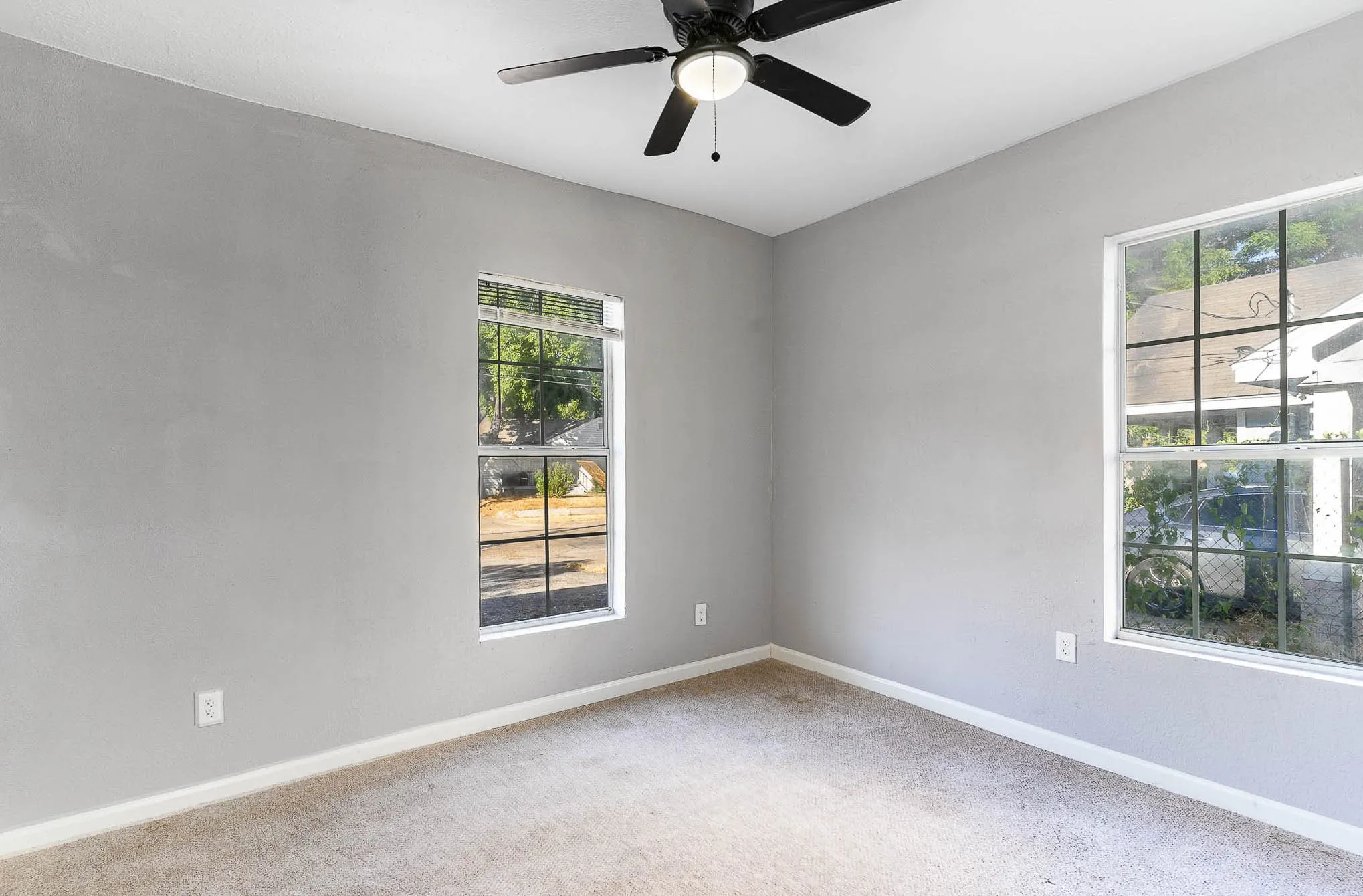 Empty room with healthy amount of natural light, light colored carpet, and baseboards