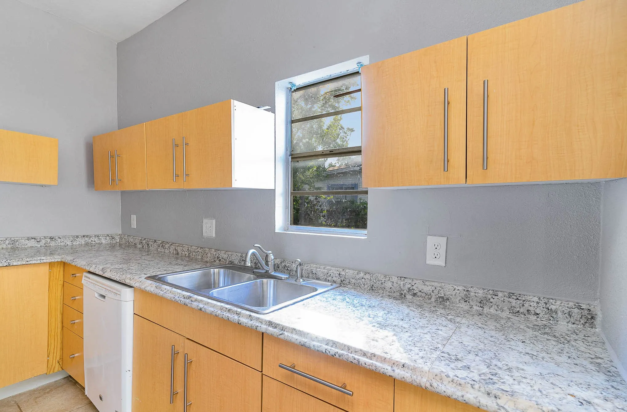 Kitchen featuring dishwasher, a sink, and light countertops