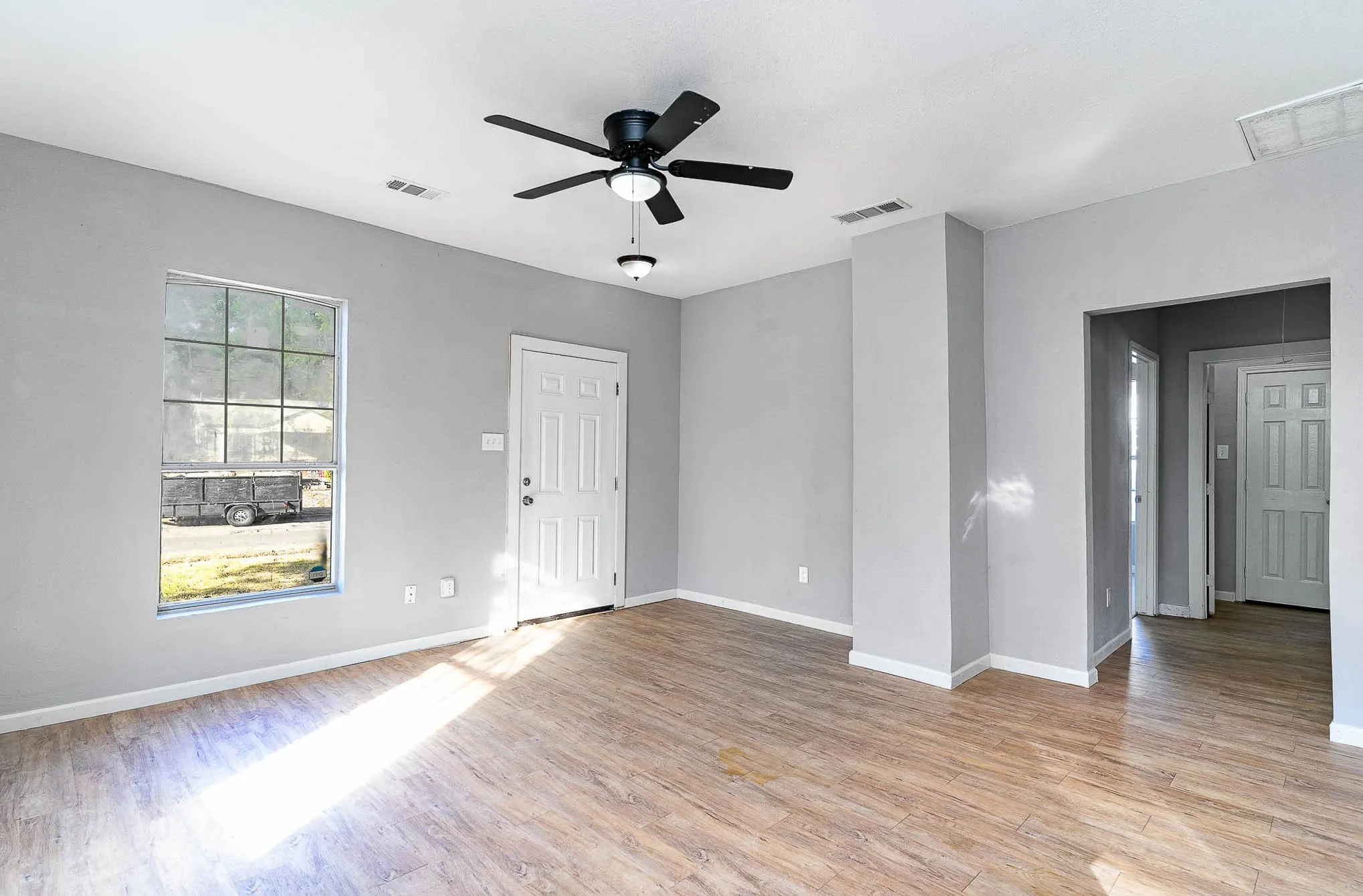 Unfurnished room with light wood finished floors, ceiling fan, and baseboards