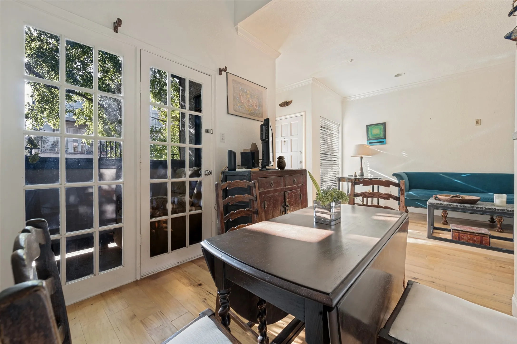 Hardwood flooring, crown molding, and white walls