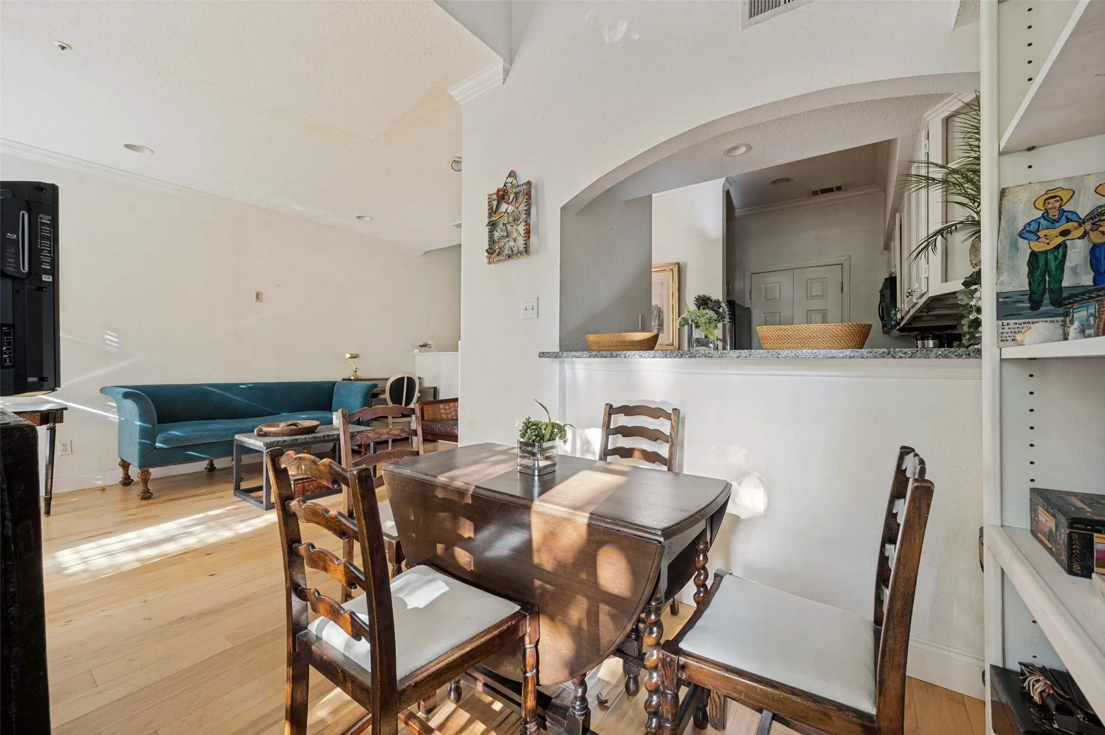 Recessed lighting, crown molding, and wood-finish flooring enhance the living area