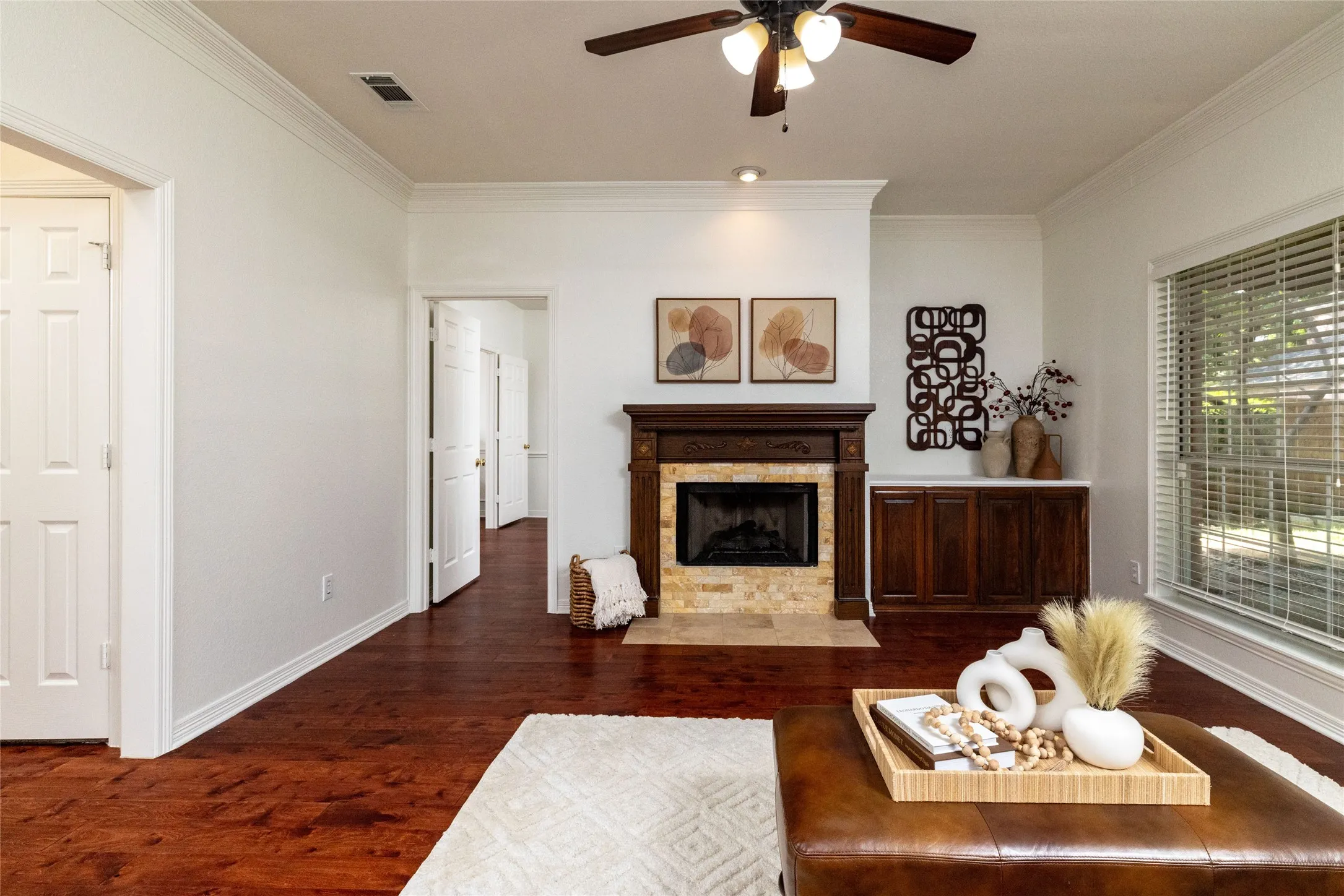 Wood-finish flooring, crown molding, and a ceiling fan with integrated lighting