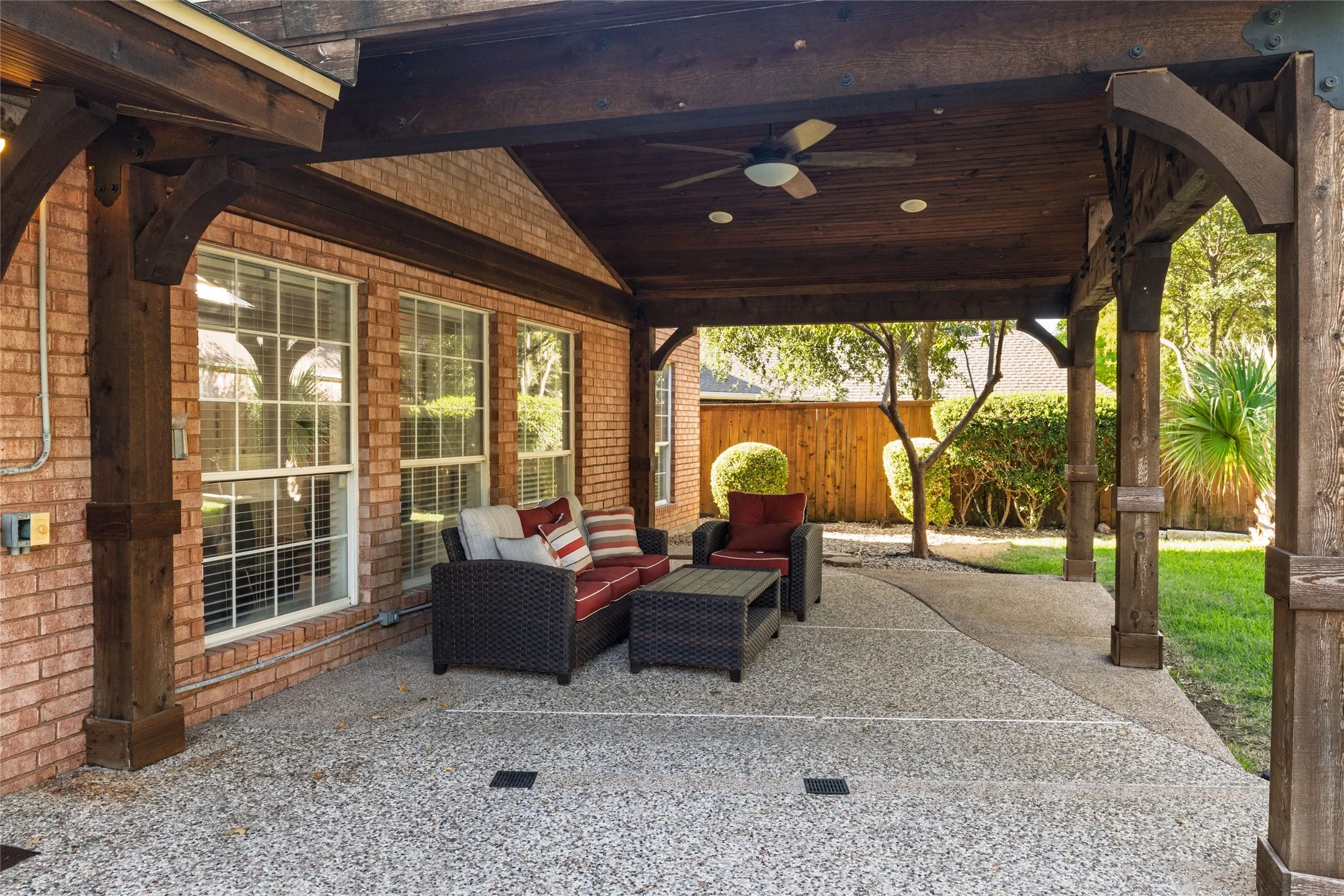 Covered outdoor living space featuring exposed wood beams, a ceiling fan, and recessed lighting