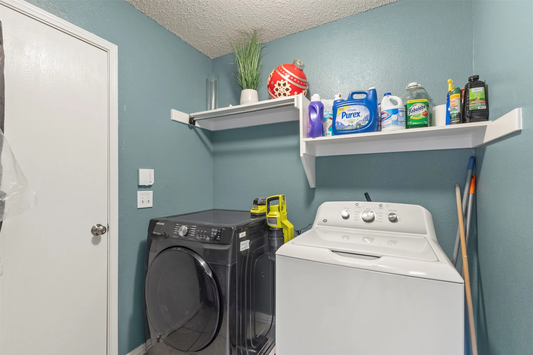 Wall-mounted shelving system above laundry appliances