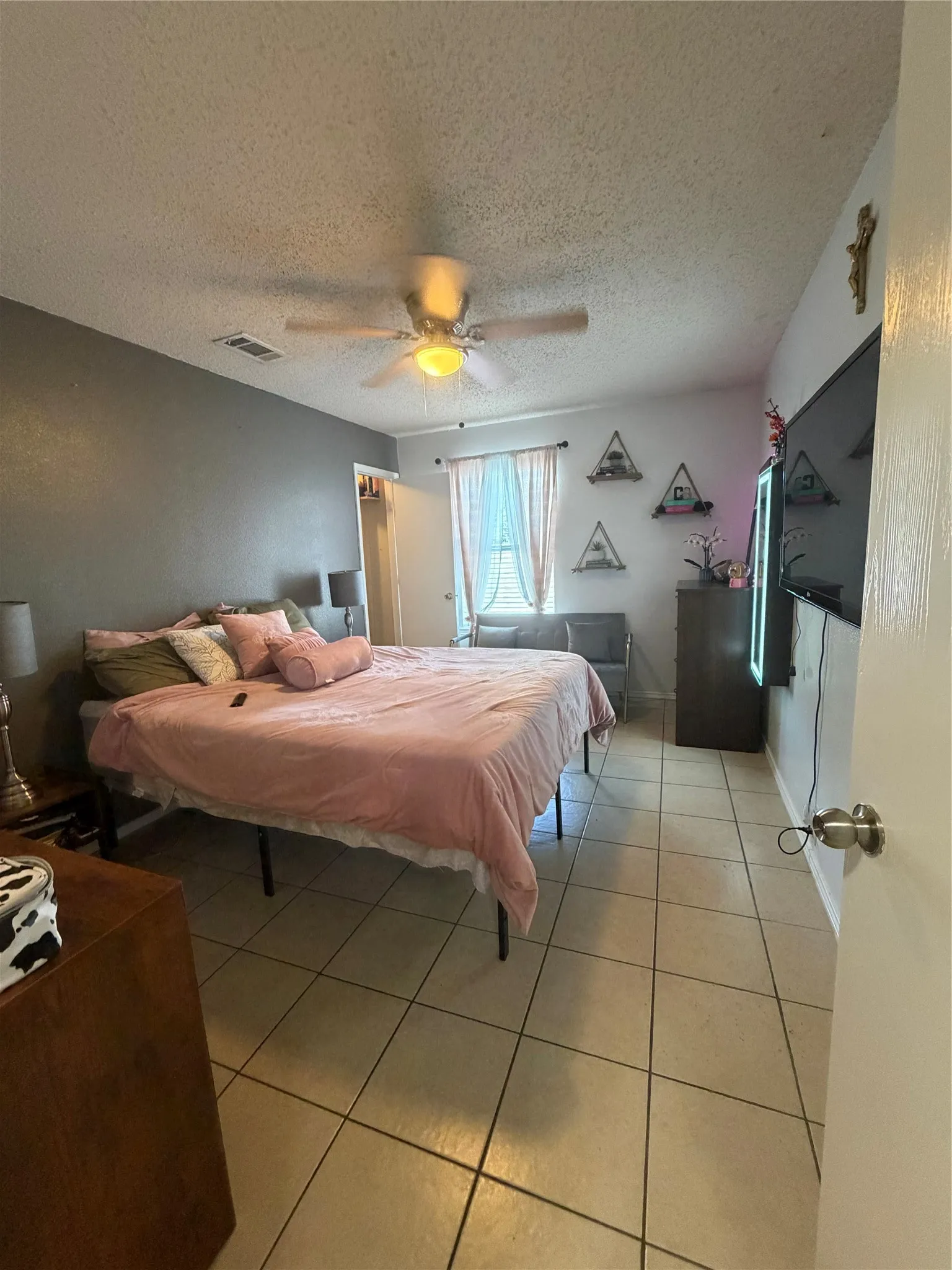 Tile flooring, ceiling fan, window with natural light, neutral wall colors