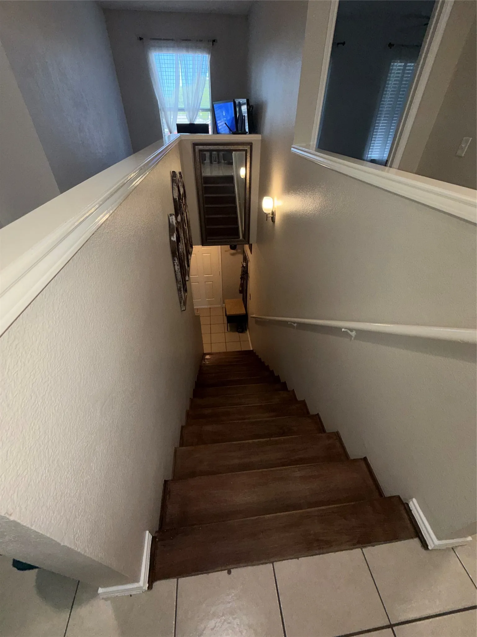 Wood-finish staircase with white risers and a white handrail