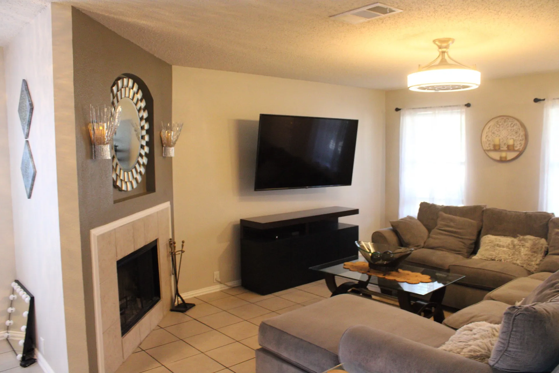 Fireplace with tile surround, built-in niche, and decorative sconces