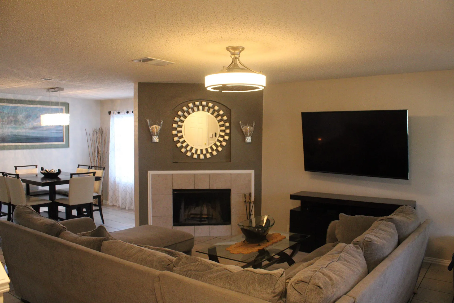 Living area with fireplace featuring a tile surround, a built-in wall niche, and a contemporary ceiling fixture