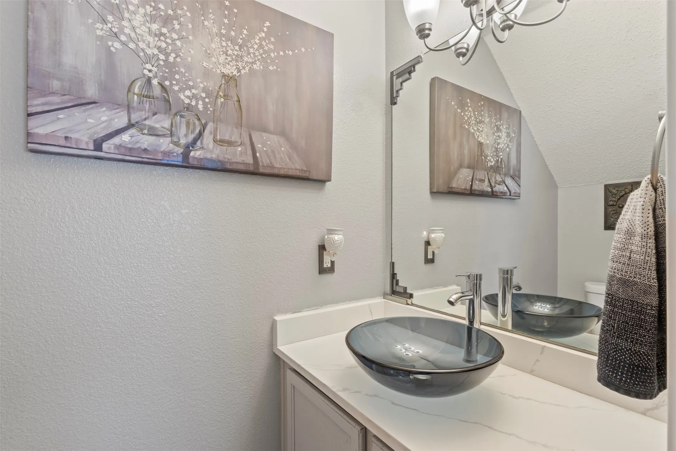 Vanity featuring a vessel sink, single-handle faucet, and white countertop