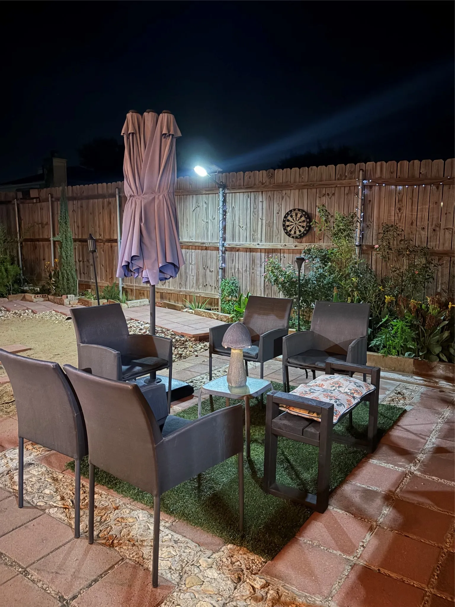 Patio area featuring brick pavers and a faux grass rug