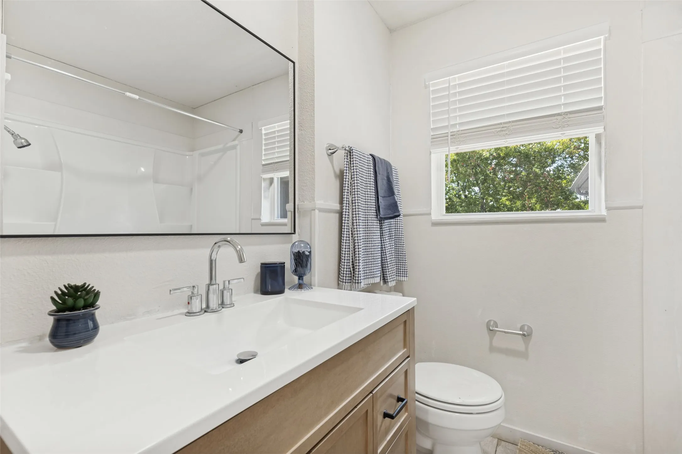 Vanity with integrated sink, chrome faucet, and wood-finish cabinetry