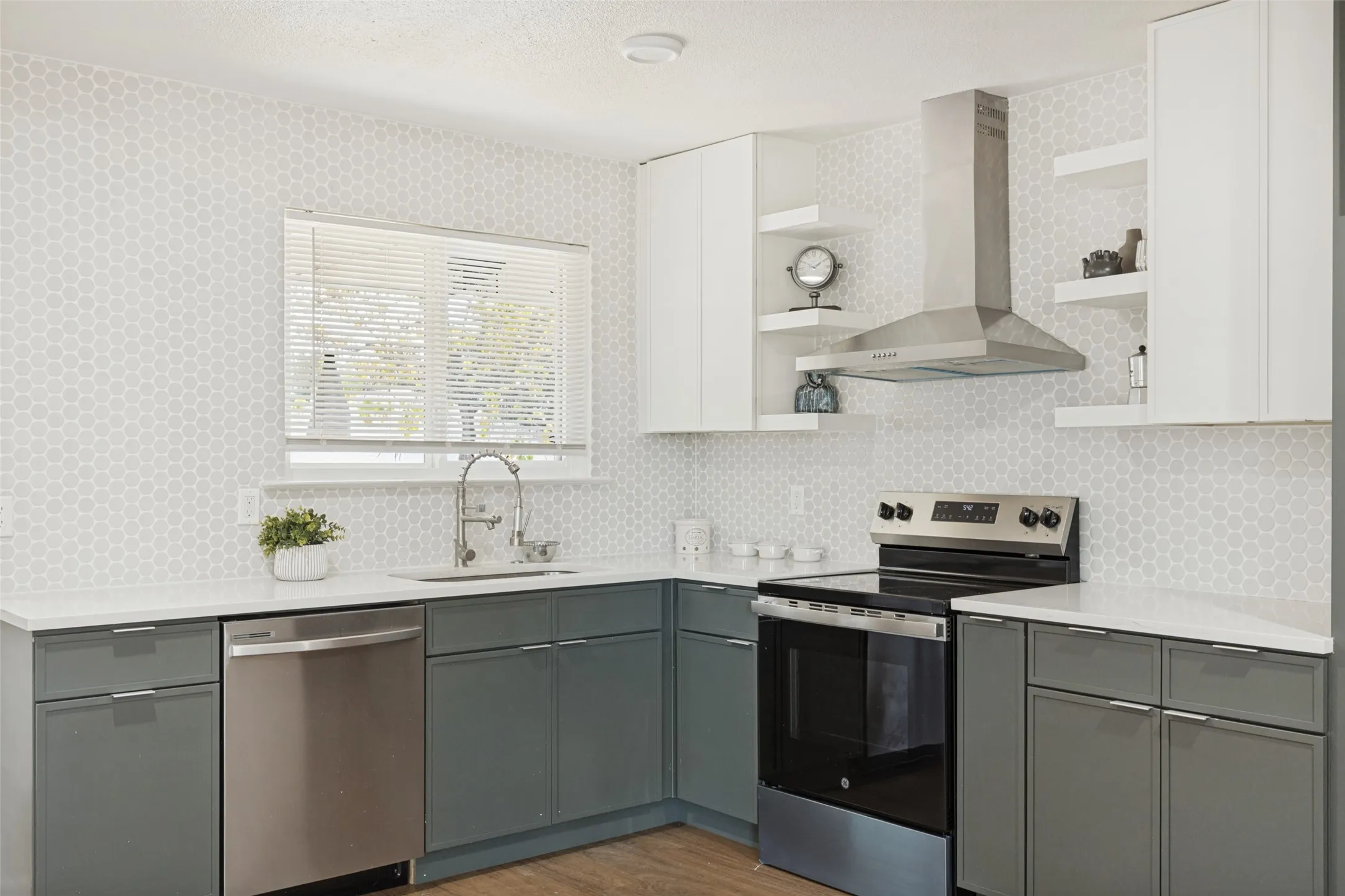 Kitchen featuring a hexagon tile backsplash, white countertops, stainless steel appliances, and two-tone cabinetry