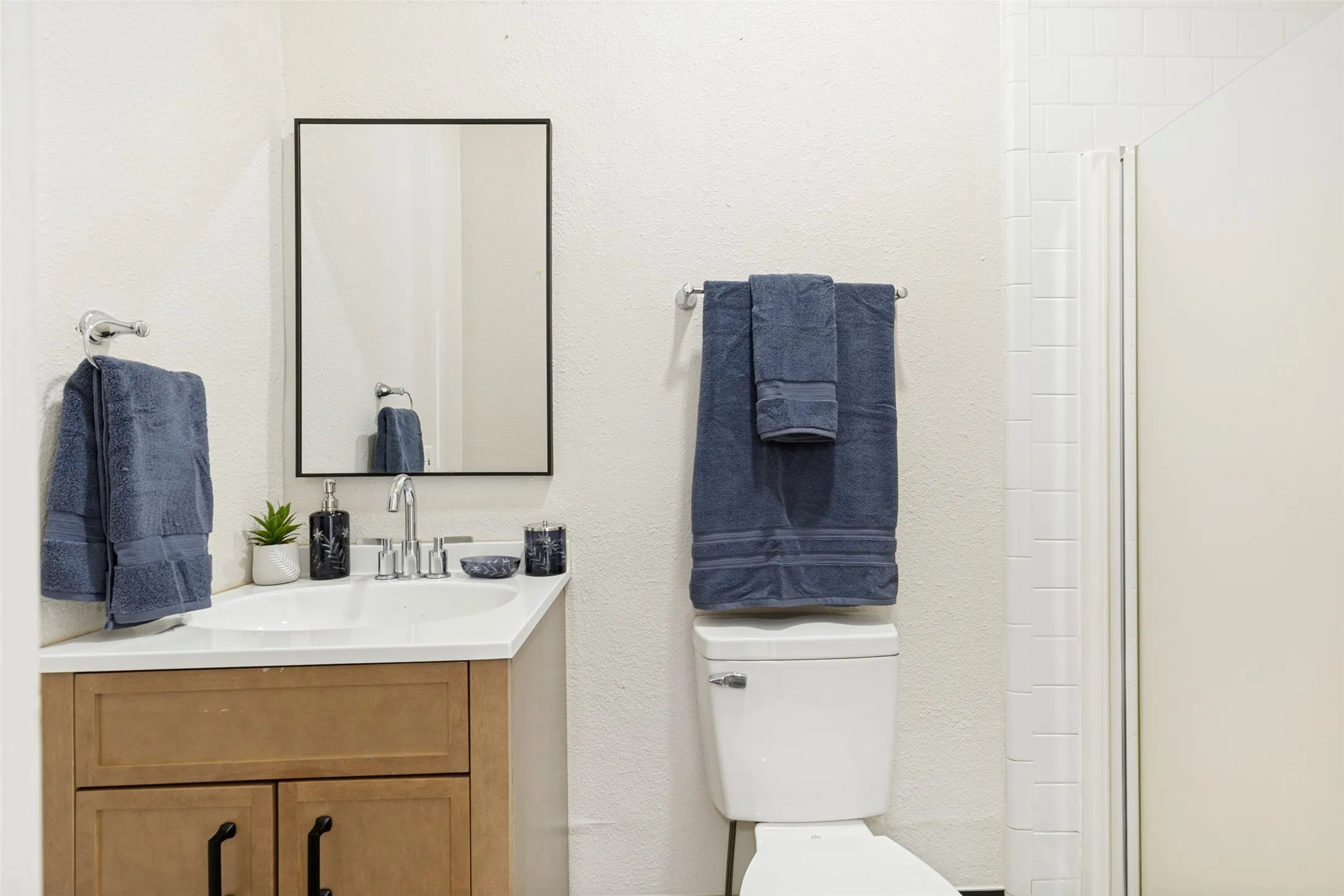Vanity with integrated sink, wood-finish cabinetry, and black hardware
