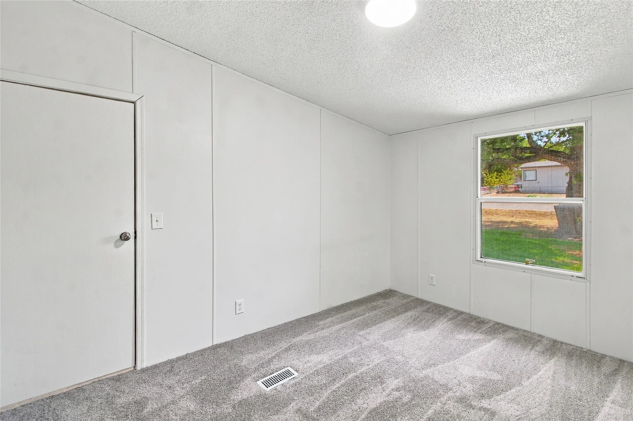 Neutral gray carpeted flooring paired with white wall paneling