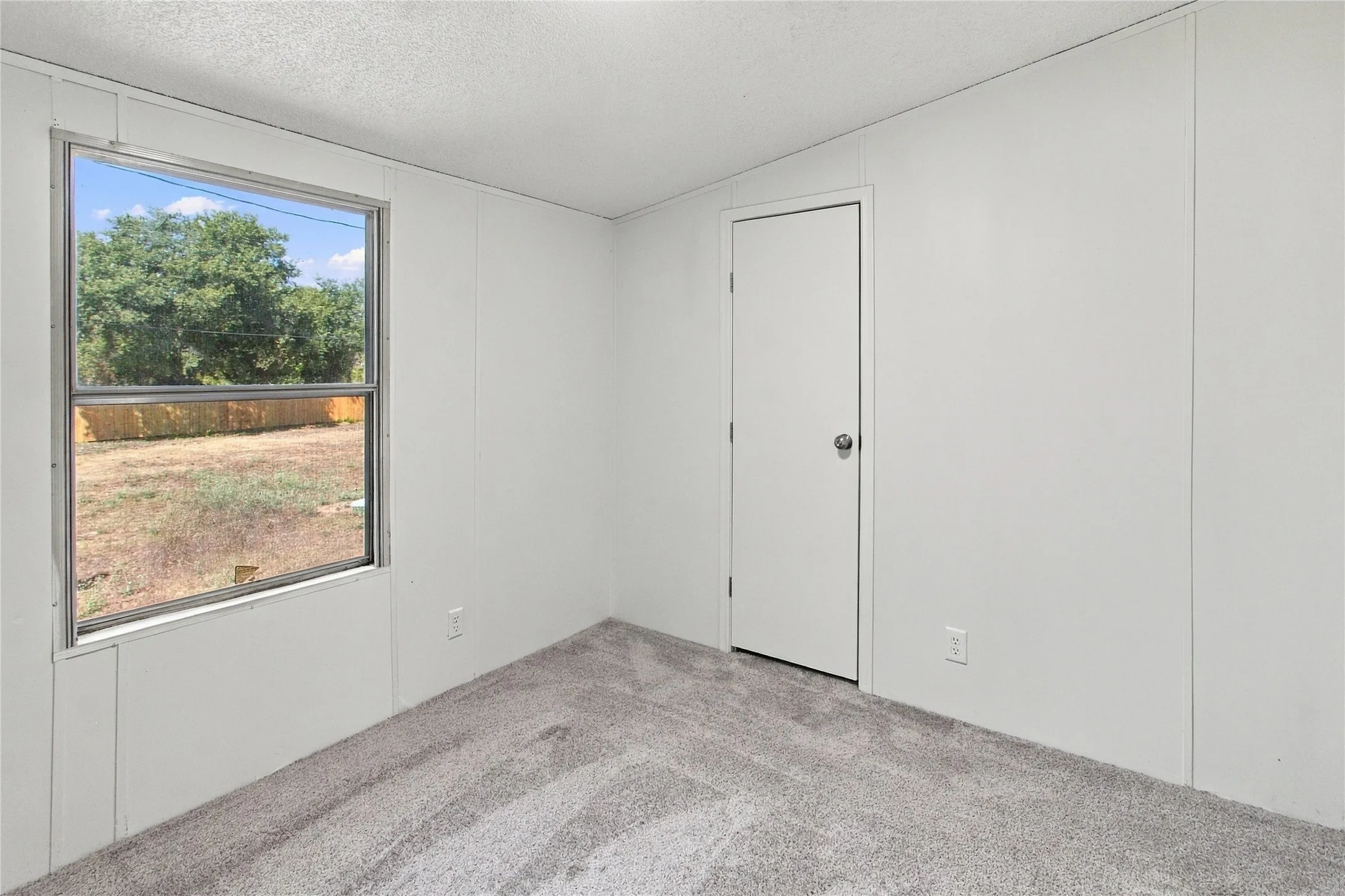 White paneled walls and a white door with a round silver knob