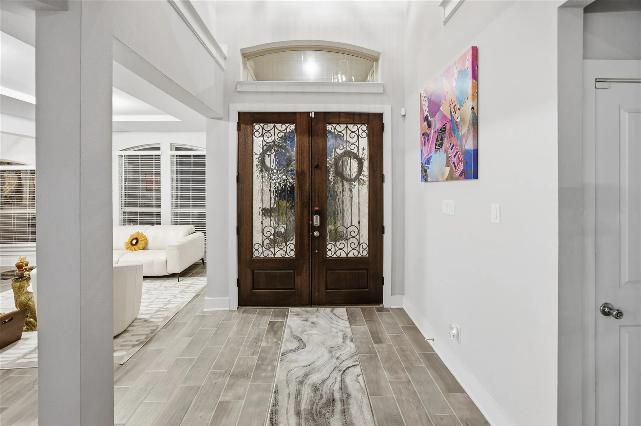 Double entry doors with decorative wrought iron and arched transom window