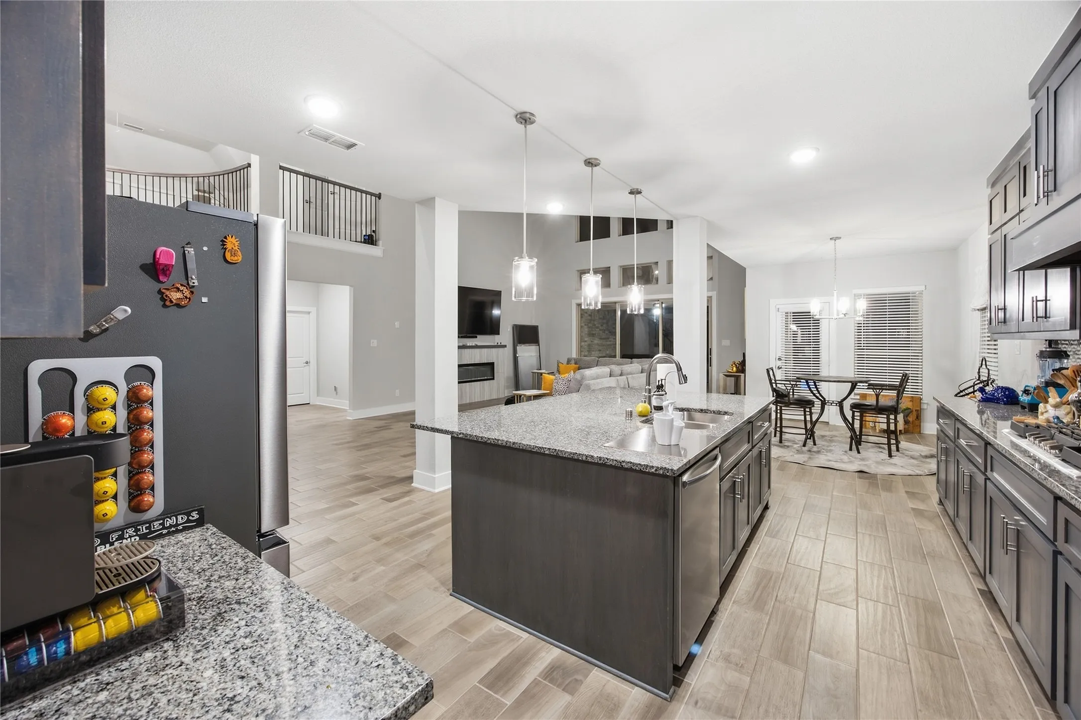 Kitchen featuring a large island with an undermount sink, granite countertops, and gray cabinetry