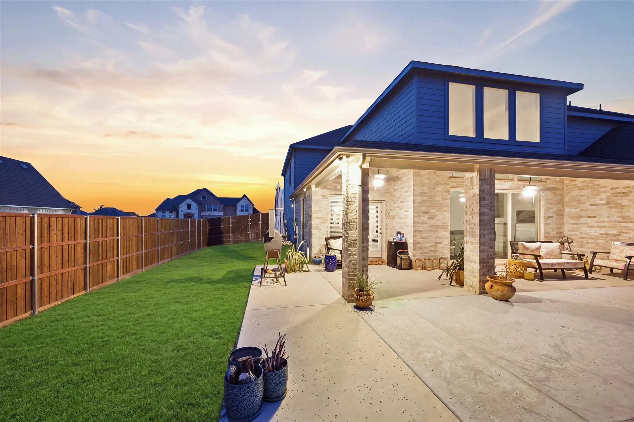 Covered patio with brick columns, concrete flooring, and recessed lighting