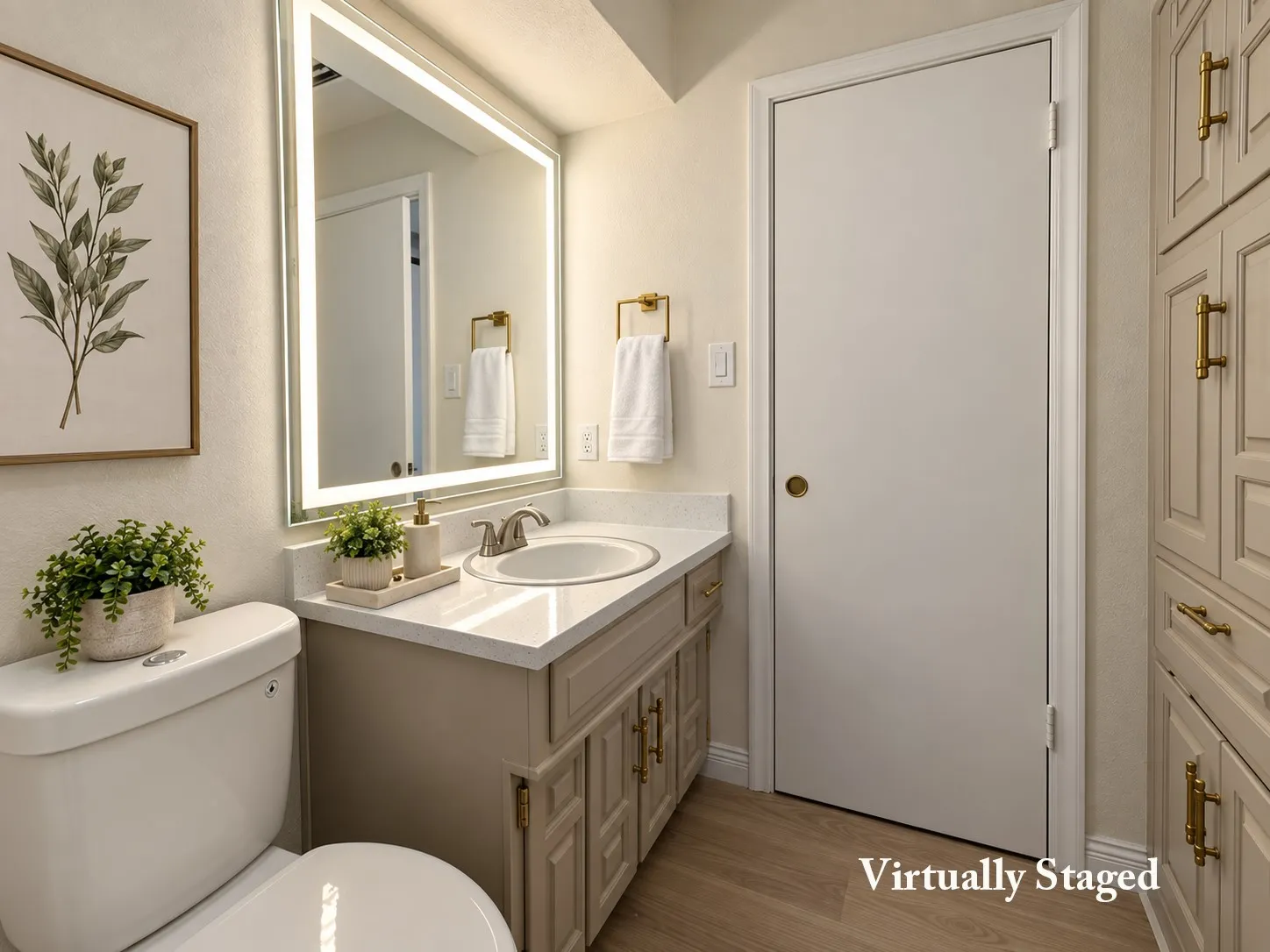 Bathroom featuring a vanity with an integrated sink, illuminated mirror, built-in cabinetry, toilet, and wood-finish flooring
