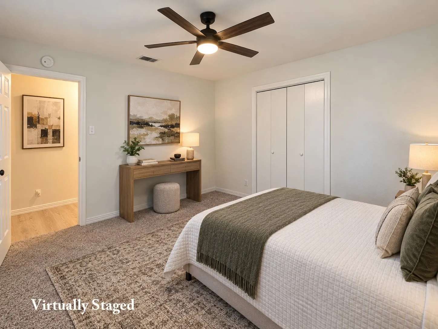 Plush carpeting, wood-finish flooring, ceiling fan, and bi-fold closet doors
