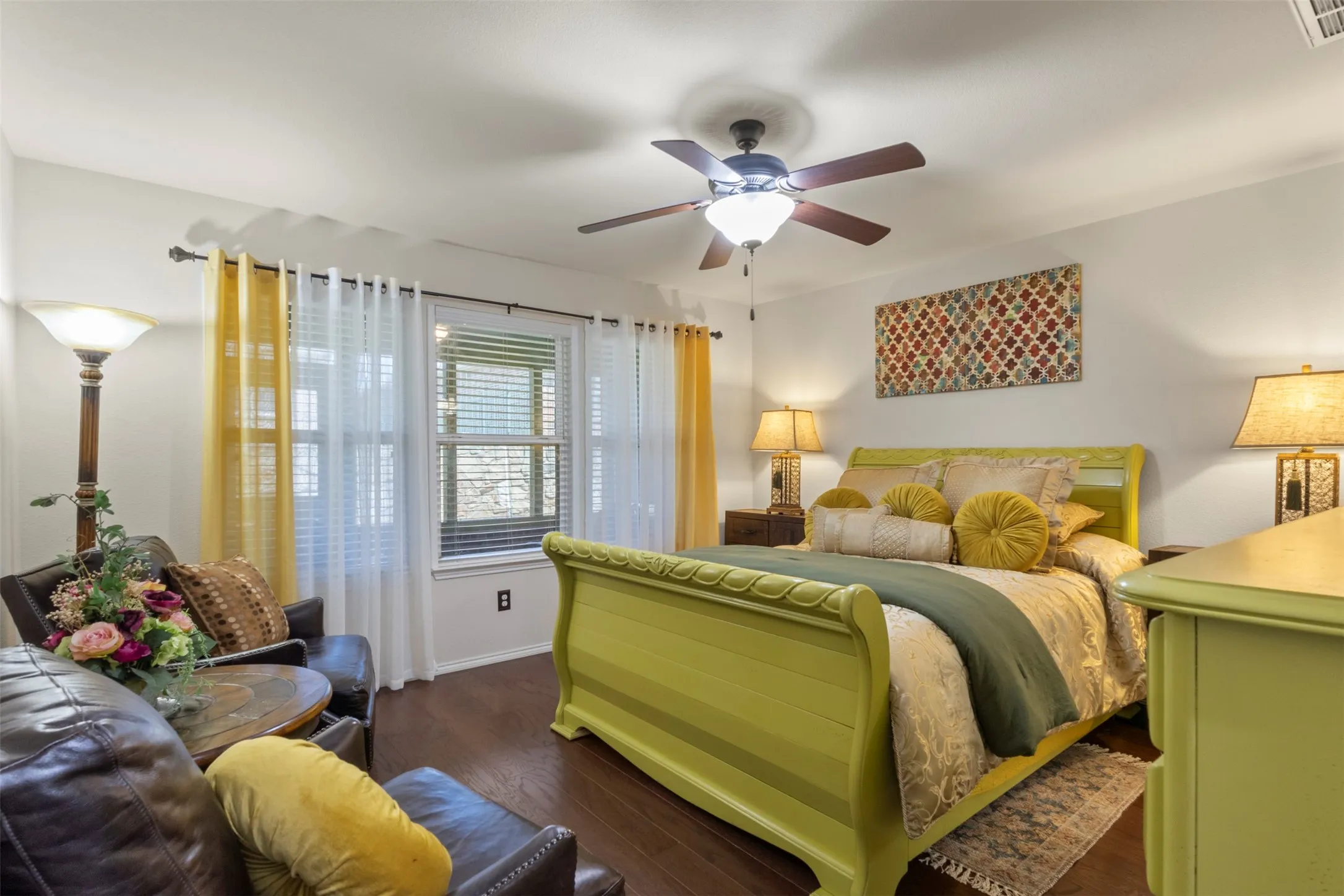 Wood-finish flooring, ceiling fan with integrated lighting, dual windows, and white walls