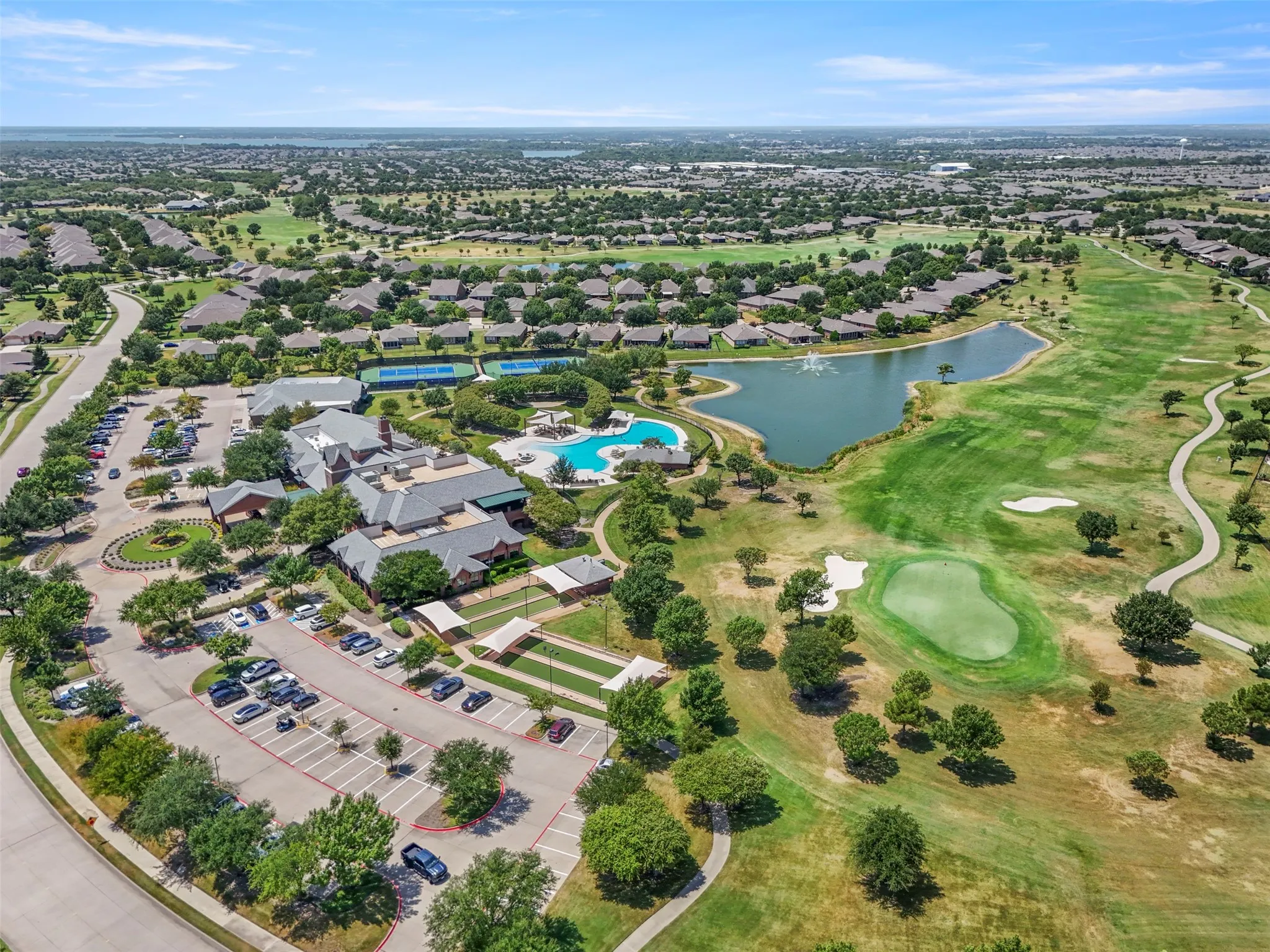 Expansive community featuring a golf course, a large clubhouse, multiple tennis courts, a resort-style swimming pool, and a community pond