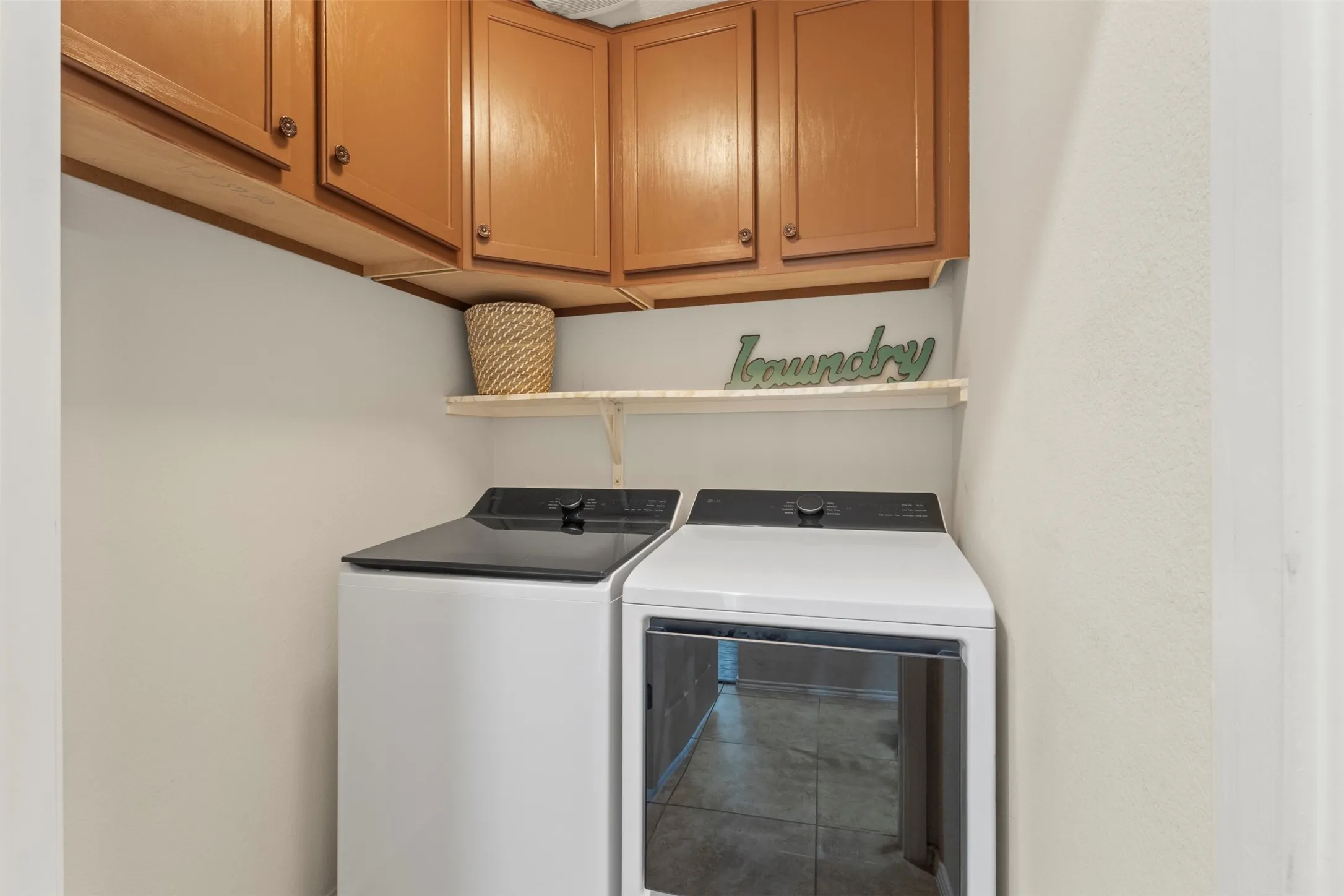 Upper cabinetry with wood-finish doors, open shelving, and tile flooring