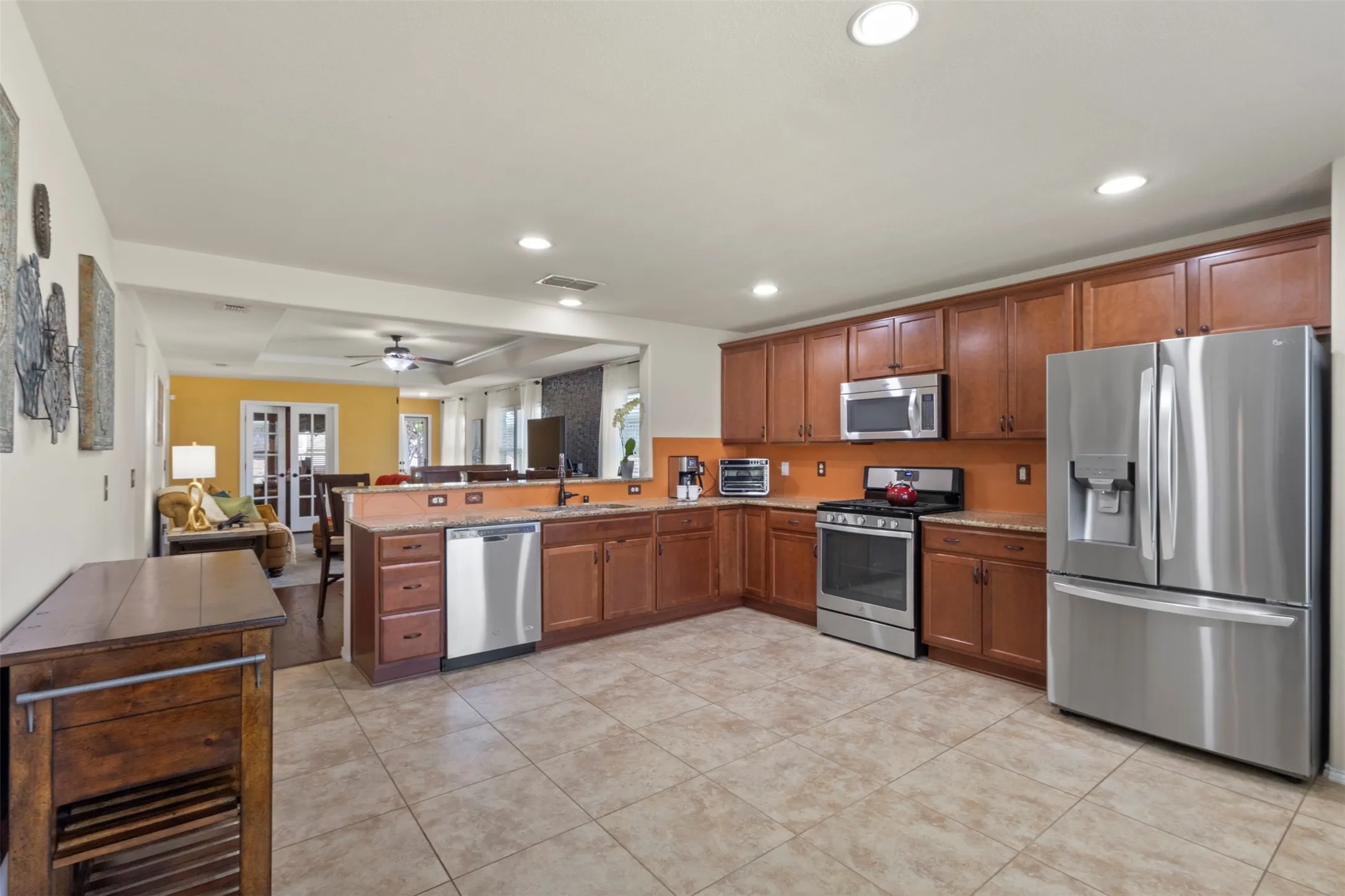 Kitchen featuring stainless steel appliances, wood cabinetry, recessed lighting, and tiled flooring