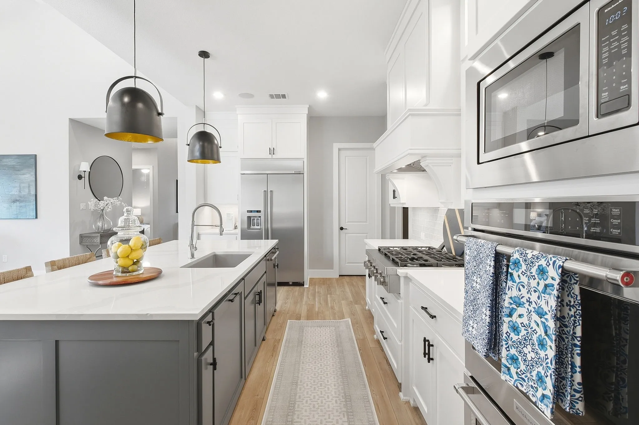 Gourmet kitchen with a large center island, white cabinetry, and stainless steel appliances