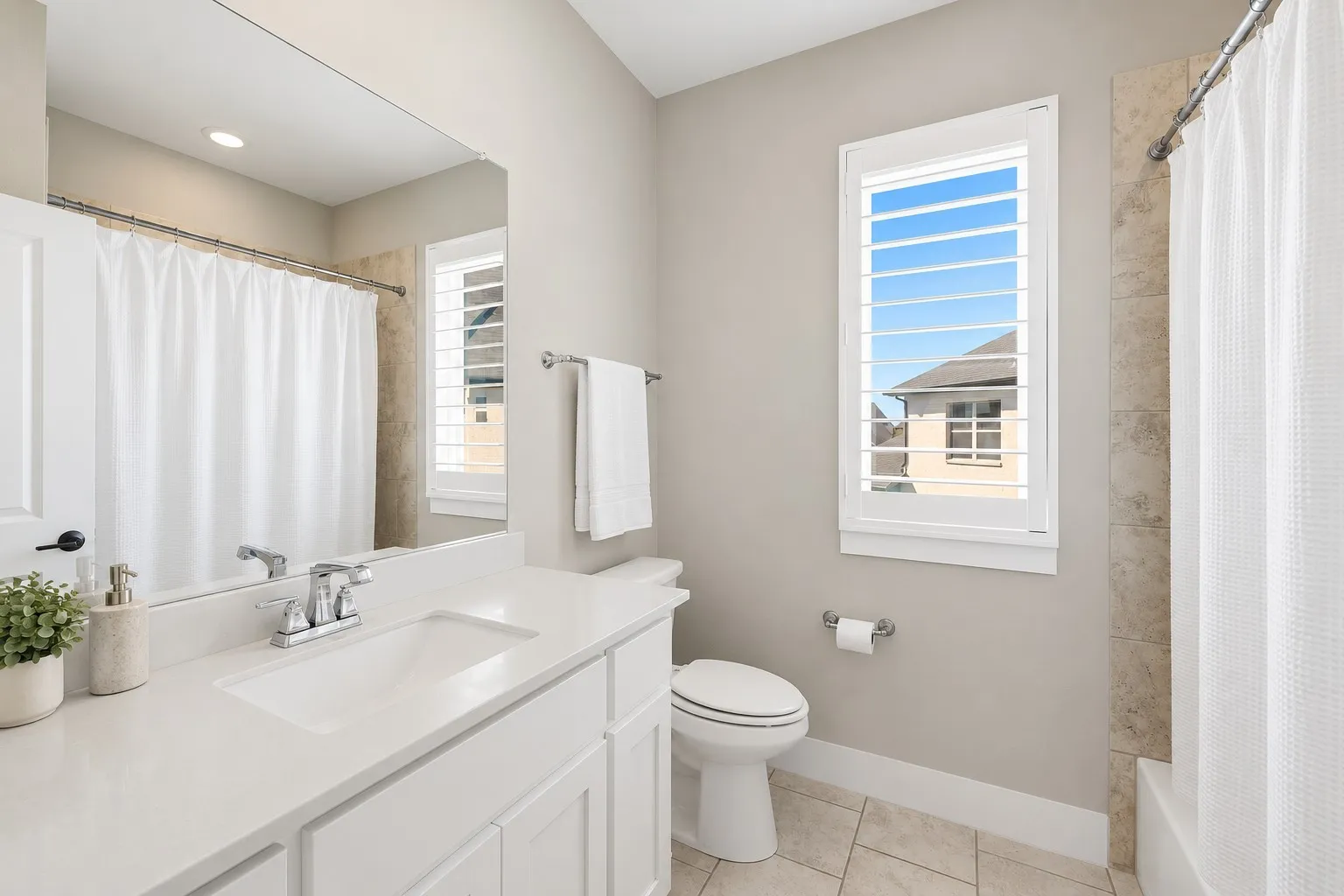 Bathroom featuring a white vanity with an integrated sink, polished chrome faucet, and a large wall-mounted mirror