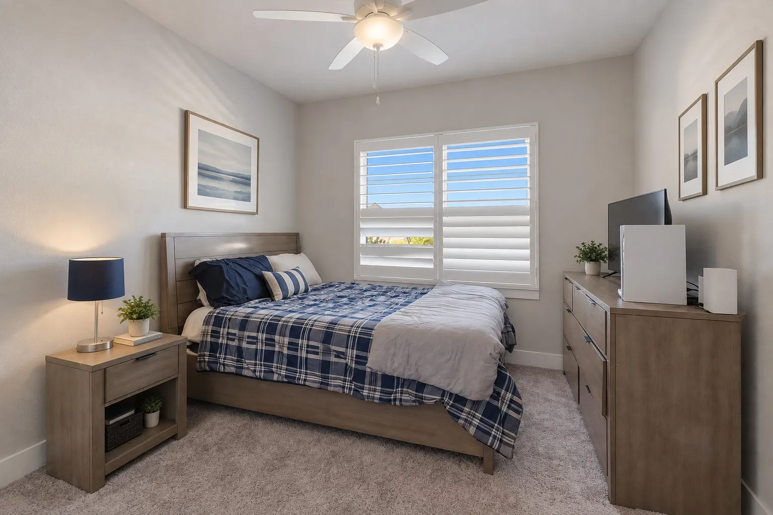 Bedroom featuring a ceiling fan, window with white plantation shutters, carpet flooring, a wood-finish bed frame, and wood-finish dresser