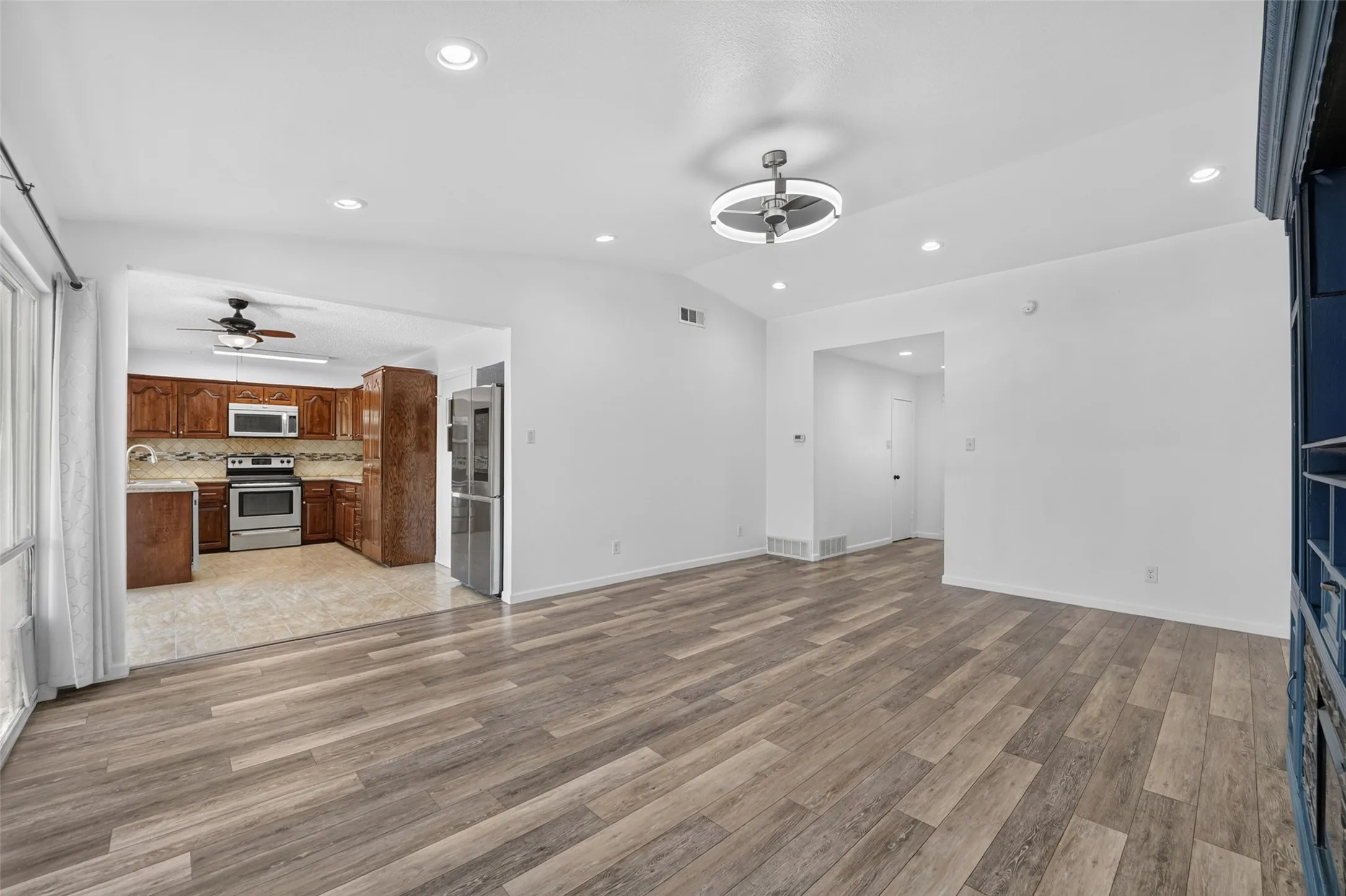 Wood-finish flooring throughout, recessed lighting, and a modern ceiling fixture