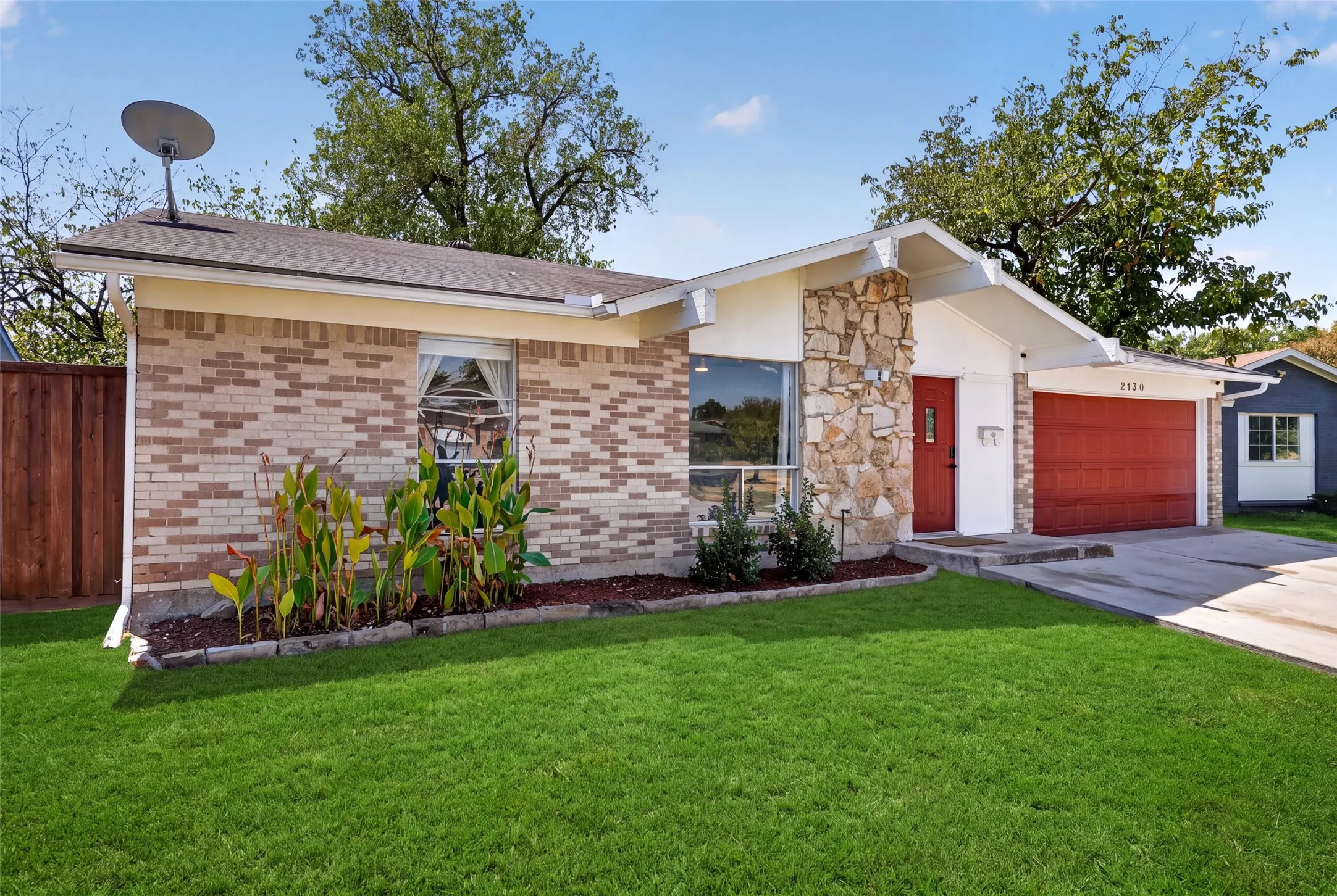 Brick and stone veneer exterior with a contrasting red garage door