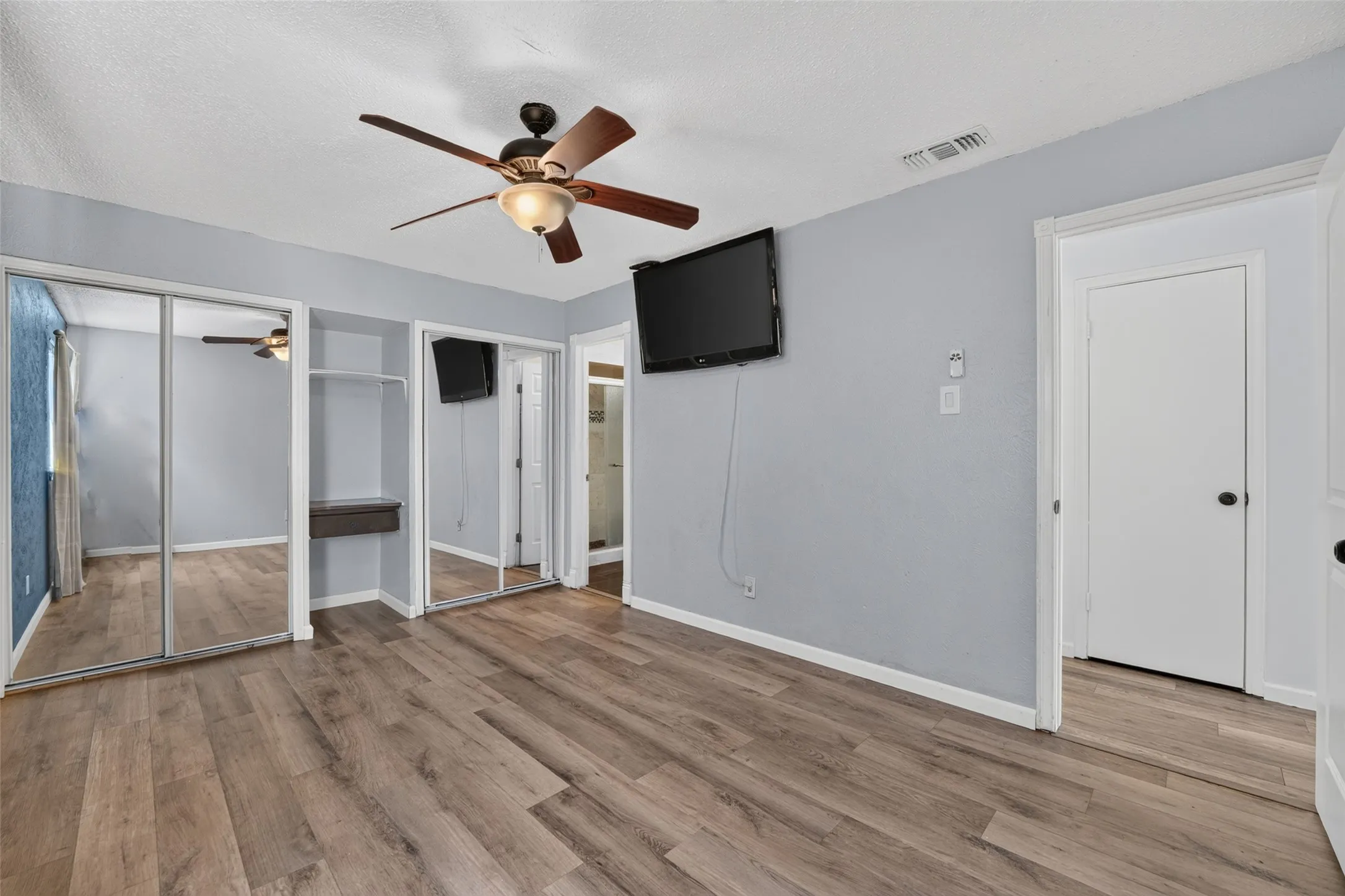 Wood-finish flooring with a ceiling fan with light fixture
