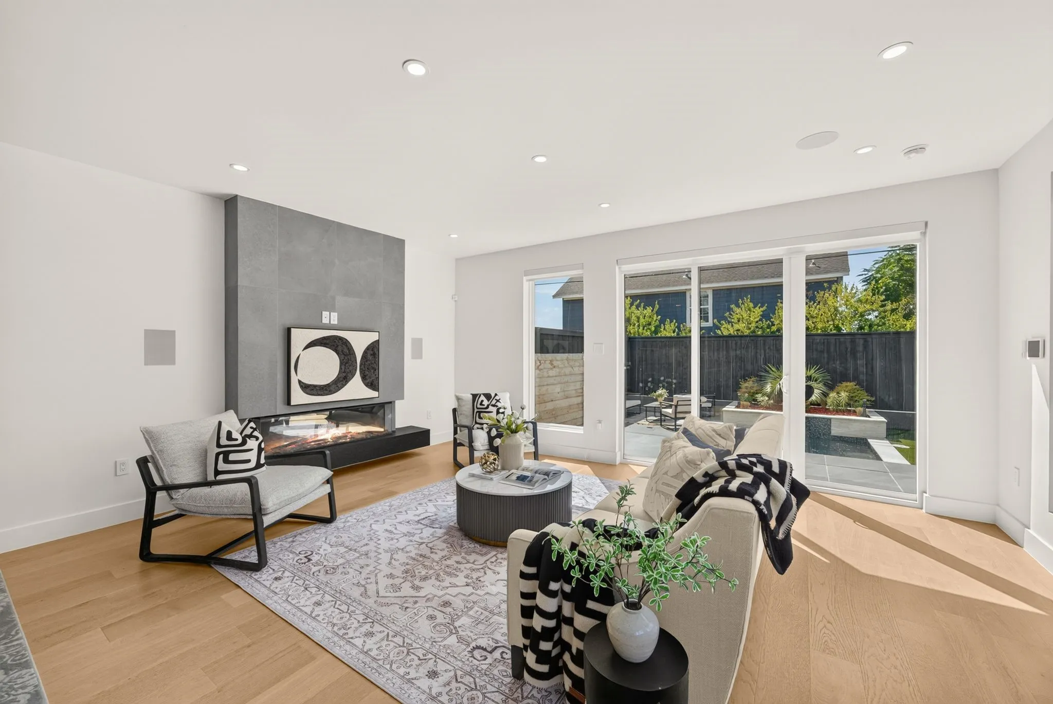 Hardwood flooring, recessed lighting, and a modern fireplace with a tile surround