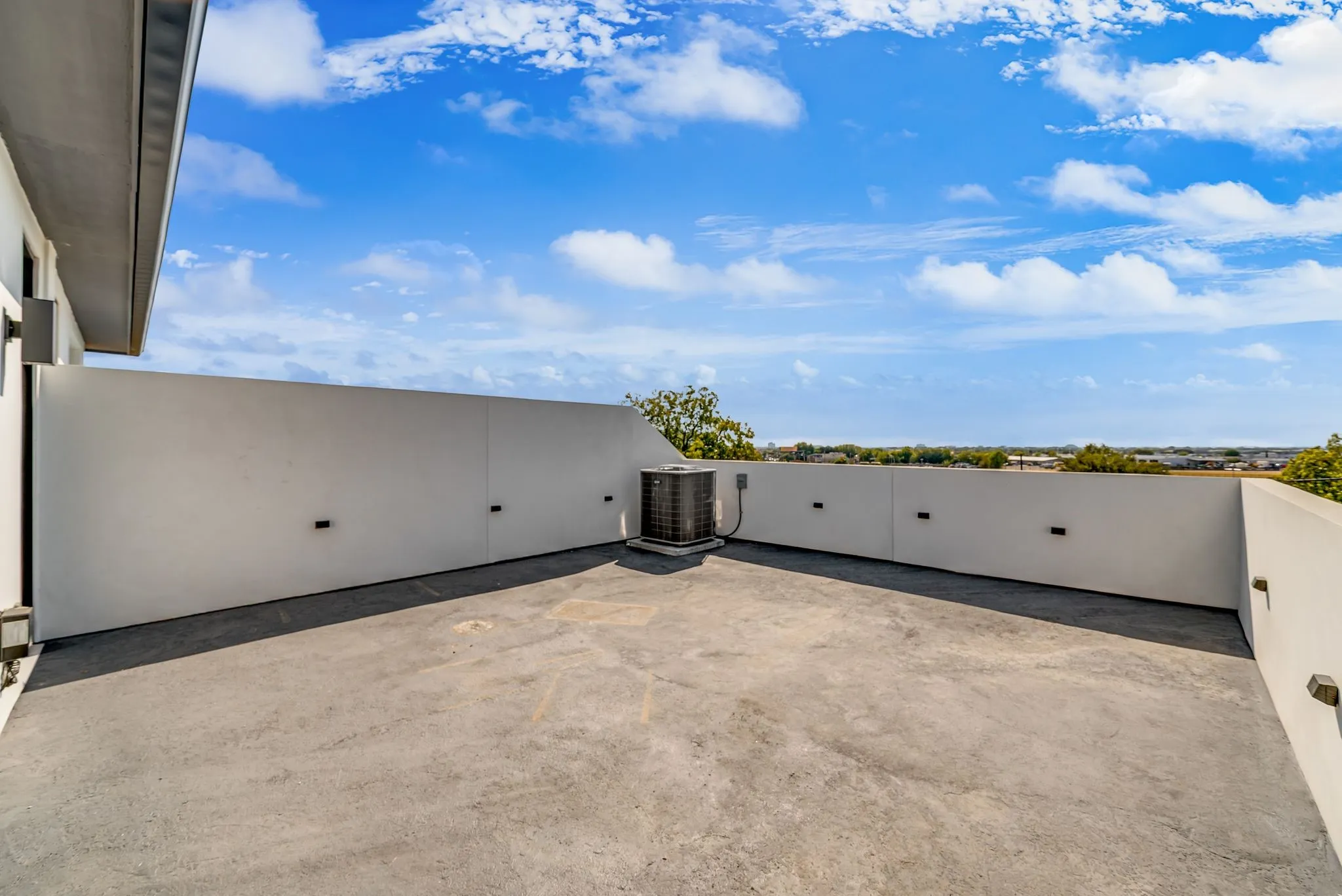 Rooftop patio with concrete flooring and perimeter wall