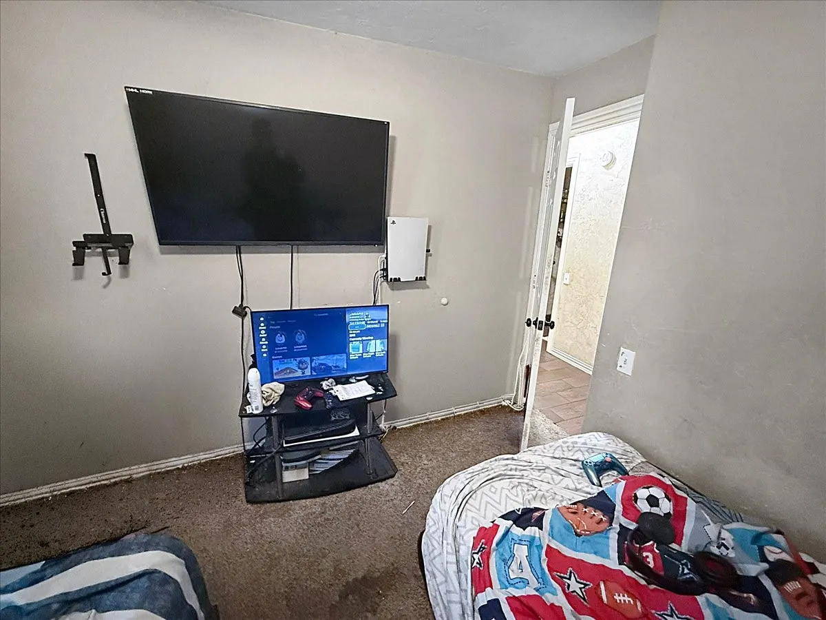 Bedroom perspective highlighting wall-mounted media setup and closet entry doorway.