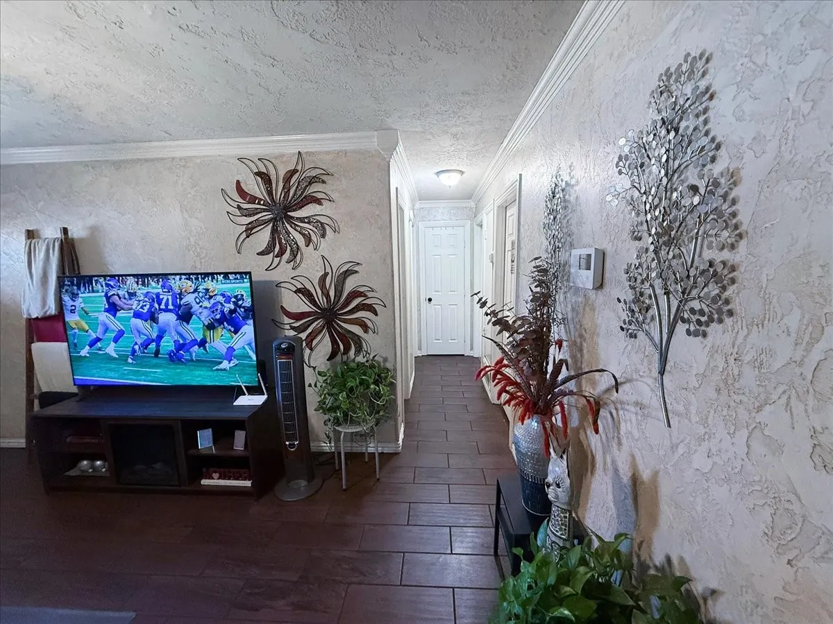 Living area hallway transition space featuring decorative wall finishes and tile flooring.