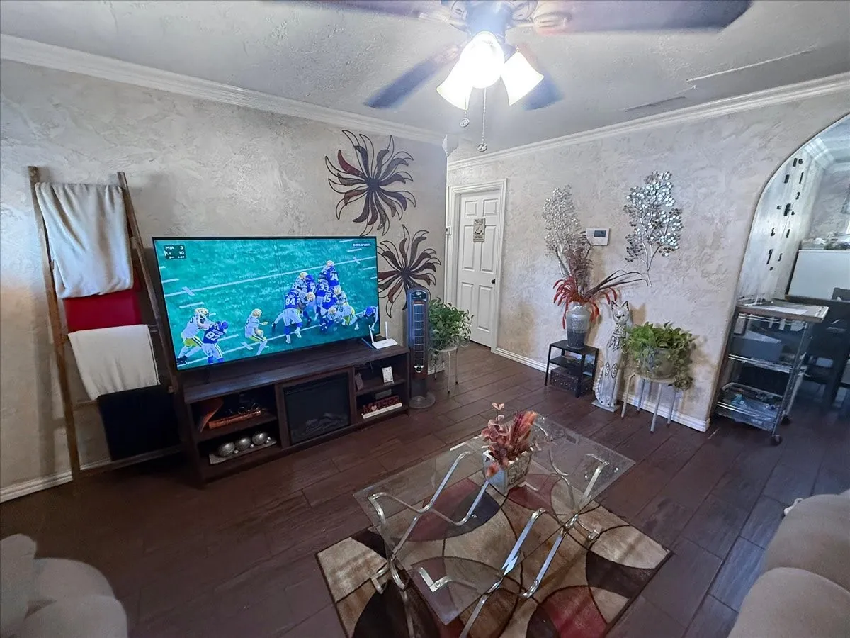 Broad view of the main living zone highlighting dark tile floors and seamless flow into adjoining areas.