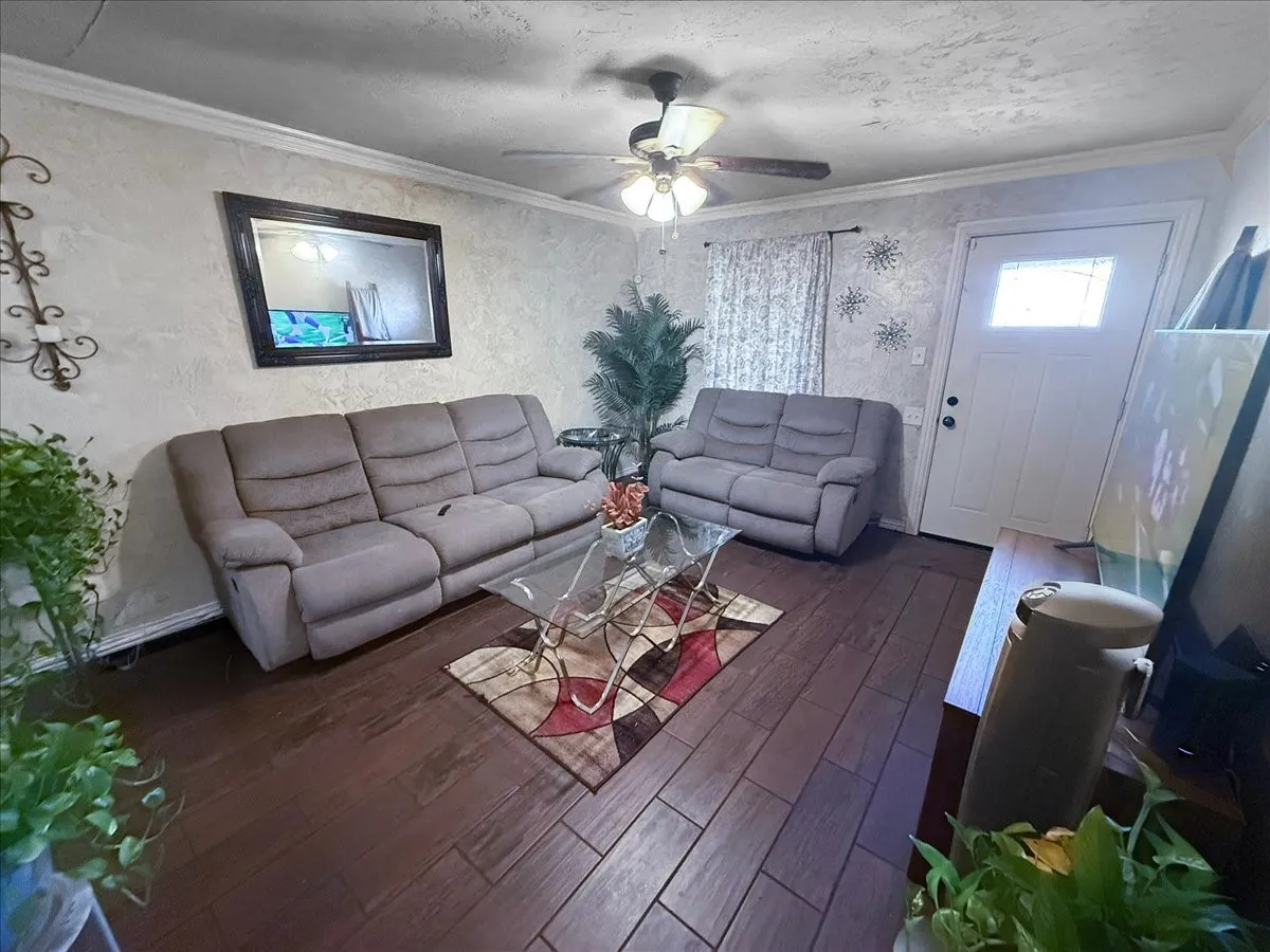 Secondary family lounge area featuring wood-look flooring, ceiling fan, and access to secondary rooms.