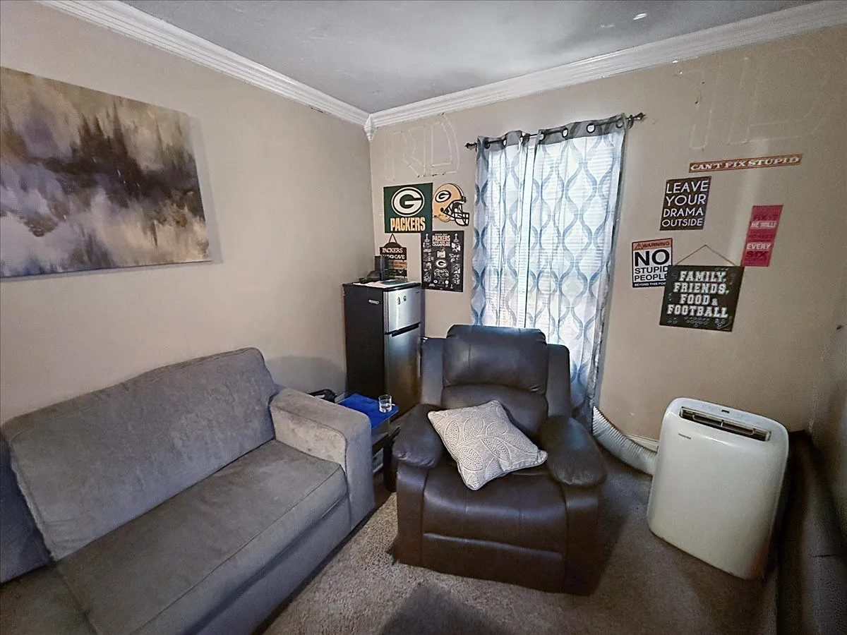 Comfortable living space featuring window lighting, crown molding, and room for sectional seating.