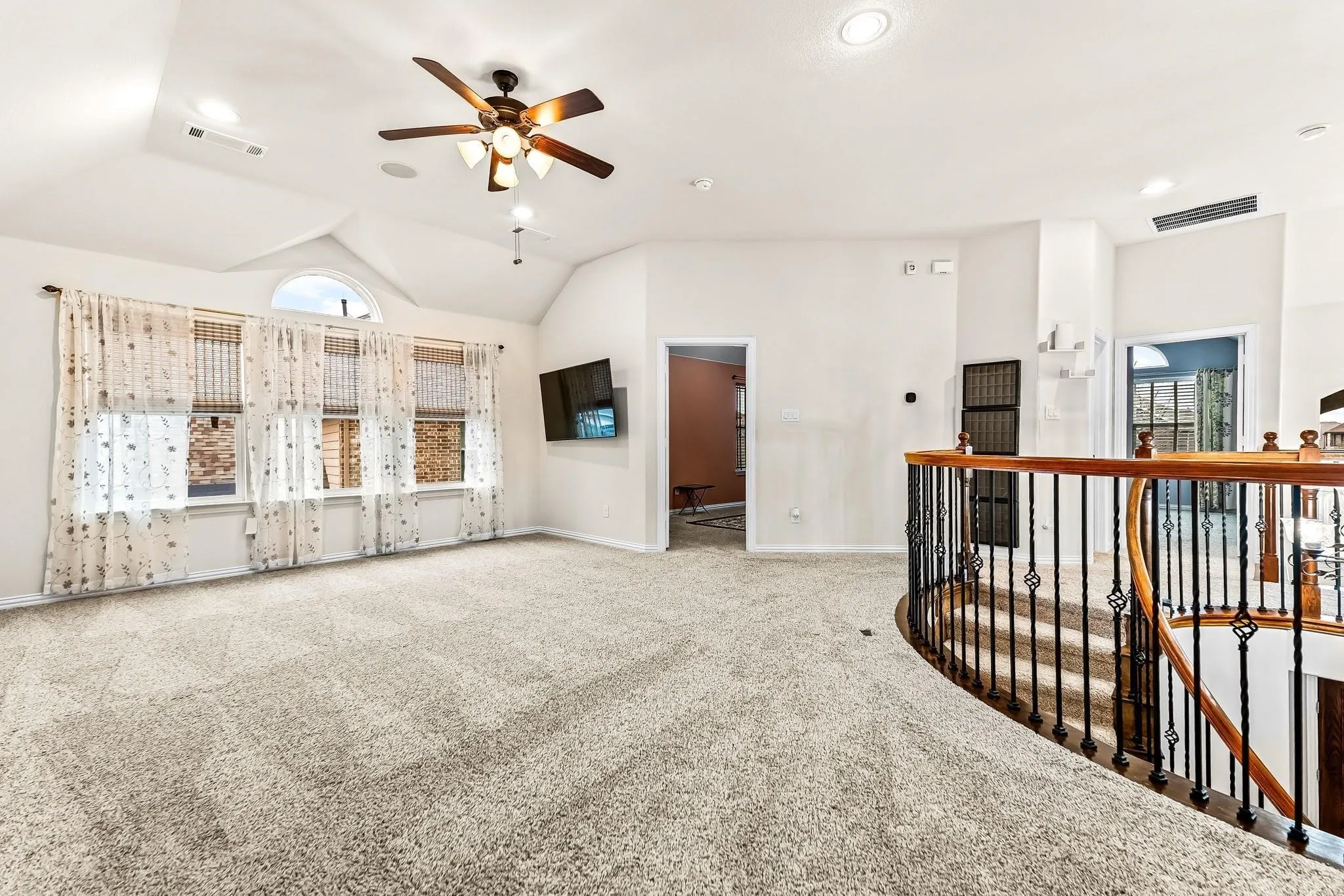 Vaulted ceiling with recessed lighting and a ceiling fan