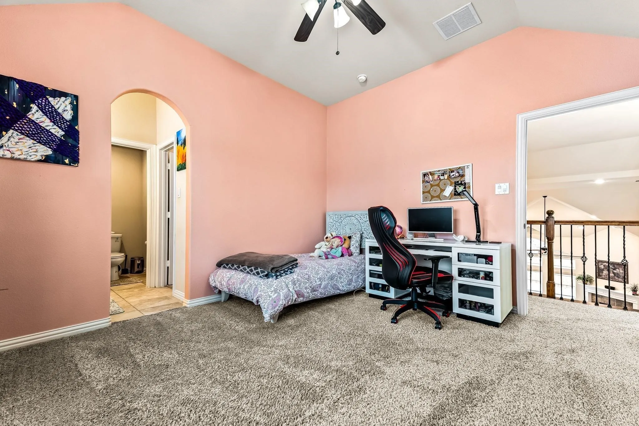 Vaulted ceiling with a ceiling fan, arched doorway, and carpet flooring